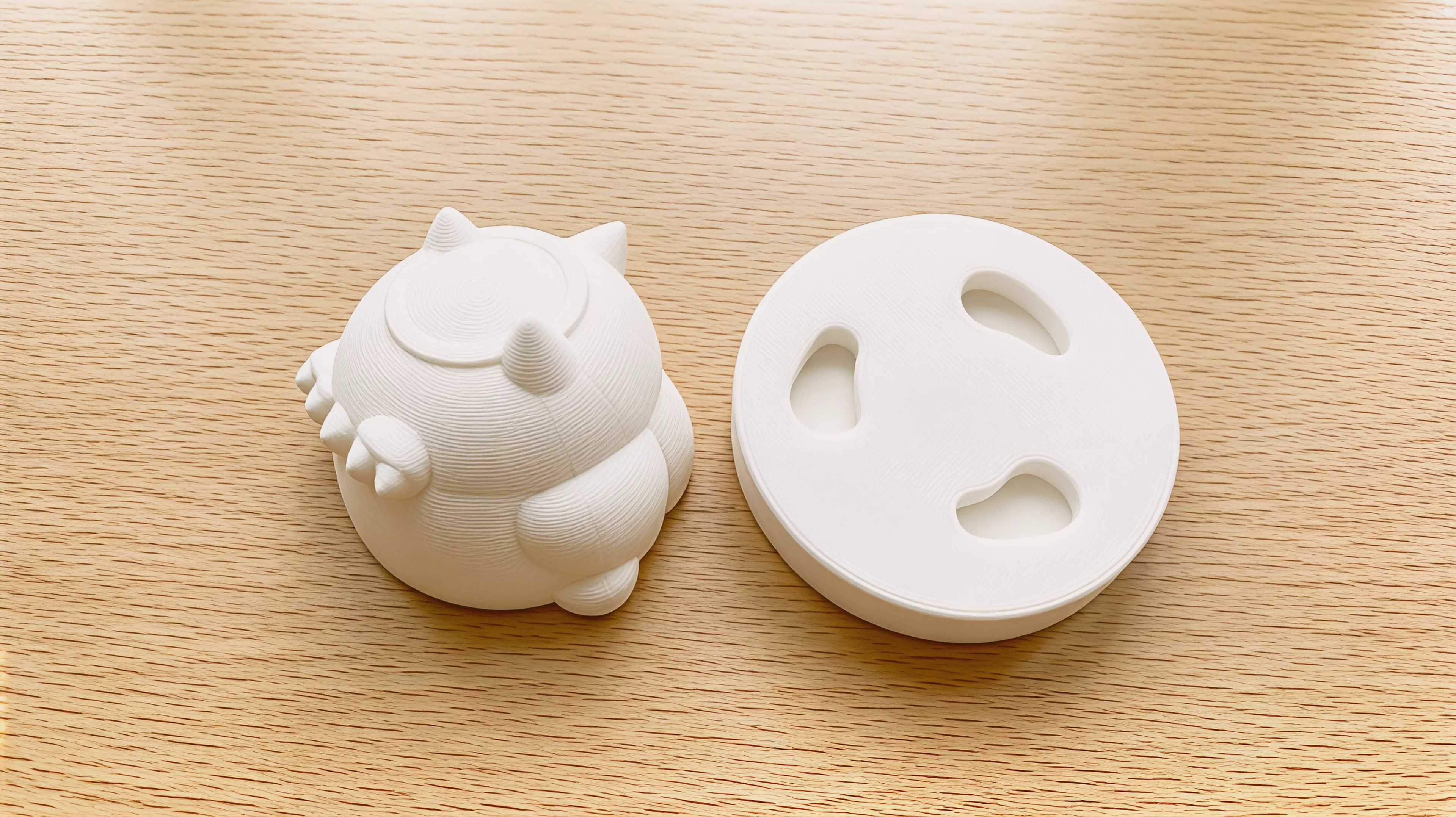 A two-part printable owl that turns about 30 degrees as three shaped feet descend through a reversible curved nest; flipping the nest reverses the turn.
