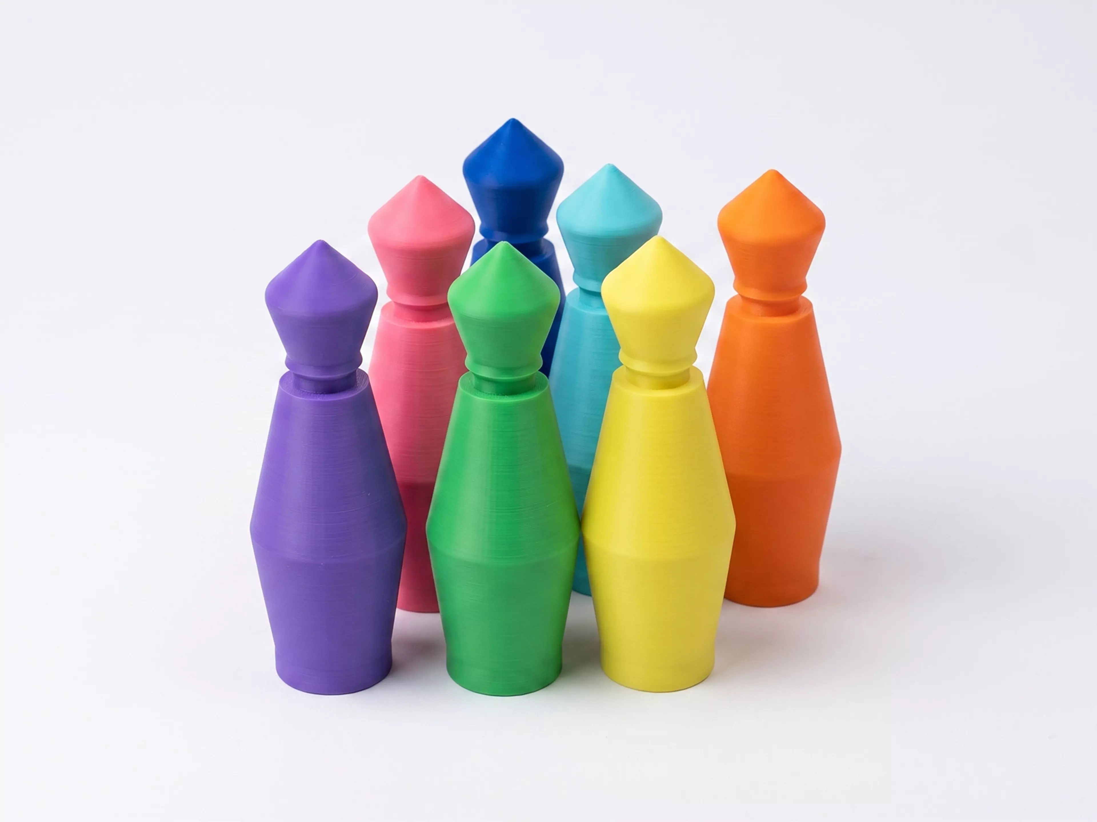 A pocket bowling toy: a lane tray that ramps into a flick-launch pad and doubles as nested storage, six molded pins in a 3-2-1 triangle, and one flick disc — flick the disc off the ramp to send it down the lane into the pins.