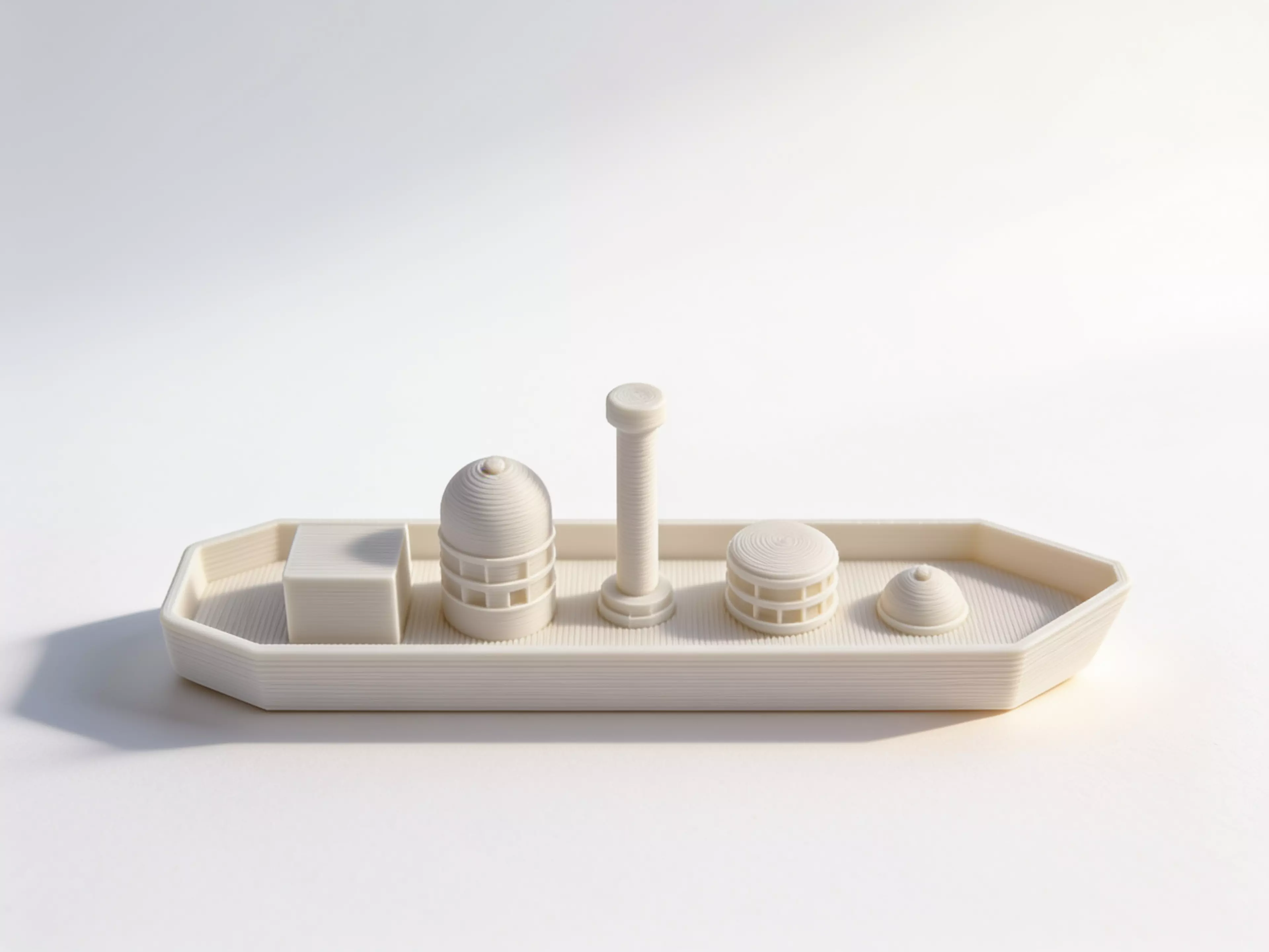 A 6-part toy cargo barge: one hull plus five separate deck-cargo pieces (crate, tall tank/silo, mast, drum, dome hatch) that peg into locating bosses on the deck, in a rugged industrial-workboat style (rivets, ribbed banding, hard chamfered hull corners).