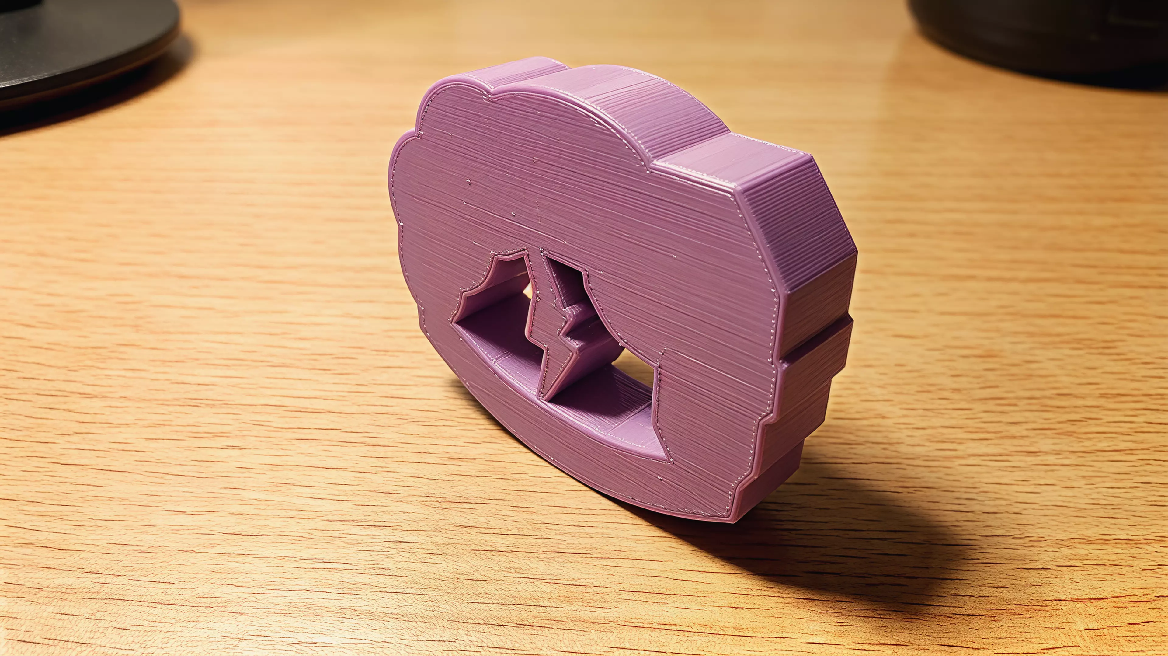 A palm-sized, one-piece storm-cloud desk rocker whose connected lightning bolt sweeps through the open arch as the whole body rocks and returns toward center.