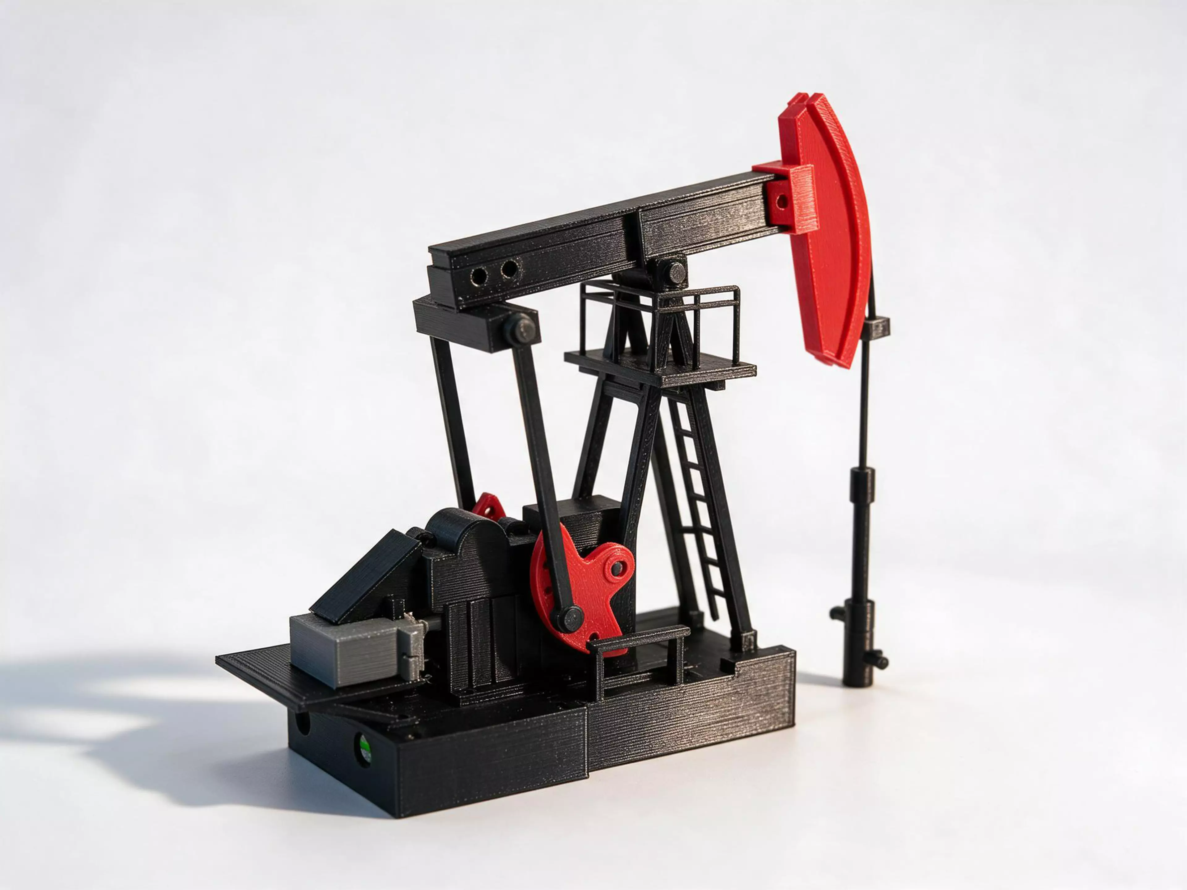 A crank-counterbalanced beam pumping unit, modelled from fourteen studio views and driven by an Adafruit 2941 gearmotor through an 8:1 worm pair into a crank-rocker four-bar: about 14 strokes a minute, 54.6 mm of polished-rod travel. Authored full size in real millimetres and reduced by one number, SCALE = 1/40 - 156.6 mm tall, 139.7 mm long, on a 220 x 220 x 250 mm bed. 21 printed parts, 30 pieces, split along the machine's own construction seams. Not verified as finished: the silhouette likeness gate scores mean IoU 0.655 against its 0.90 floor across four reference views, and the print gates have not been run, so printability is unverified. Layout, bed fit, the local fit audit, spec numbers and format, the landmark ledger, mounts, power, motion and a 47-request topology batch all passed.