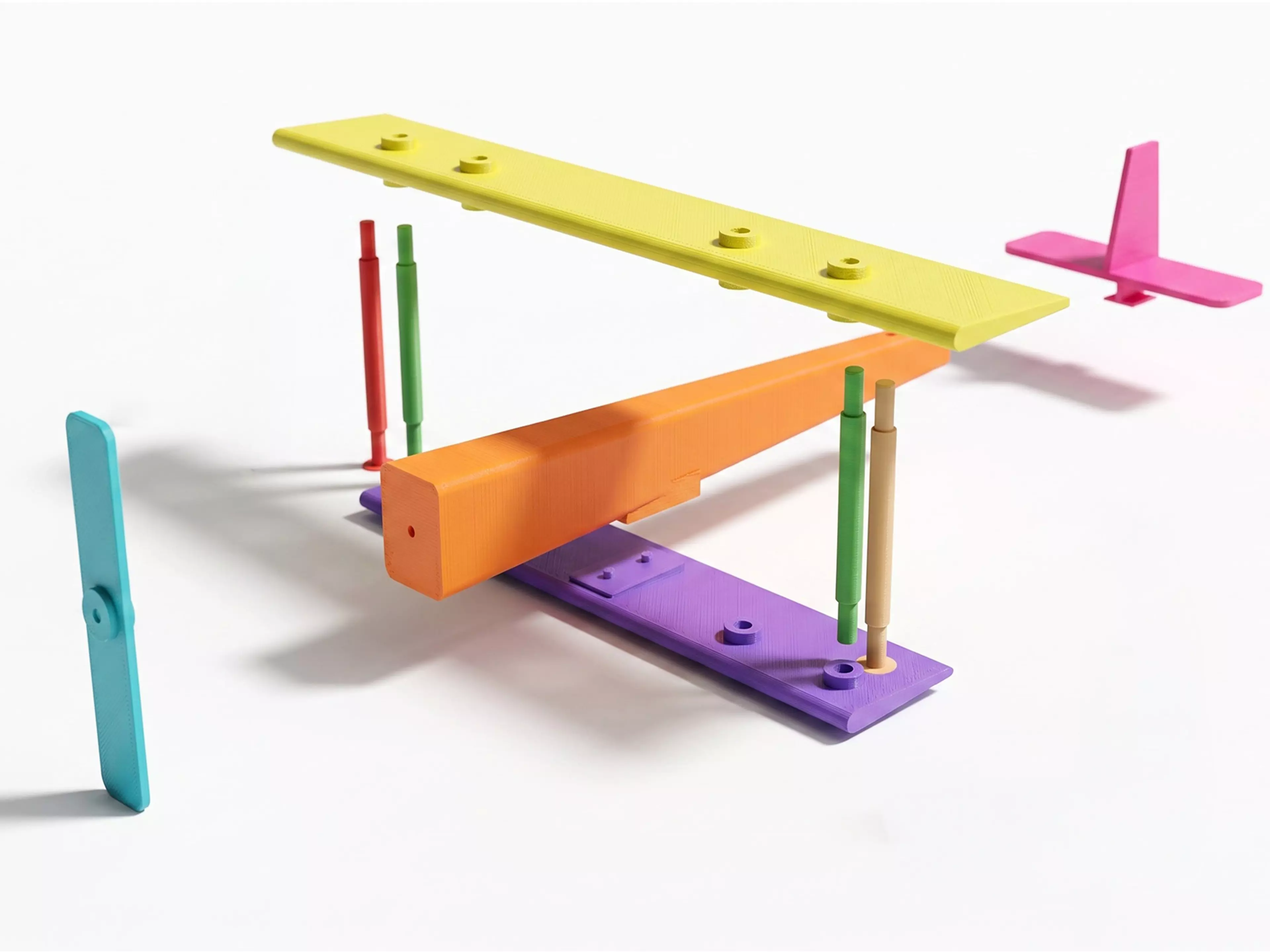 A pocket-size rubber-band-powered vintage biplane: a two-wing hand-launch glider with a free-spinning propeller driven by a twisted rubber-band motor housed in the fuselage, all in a single print color.