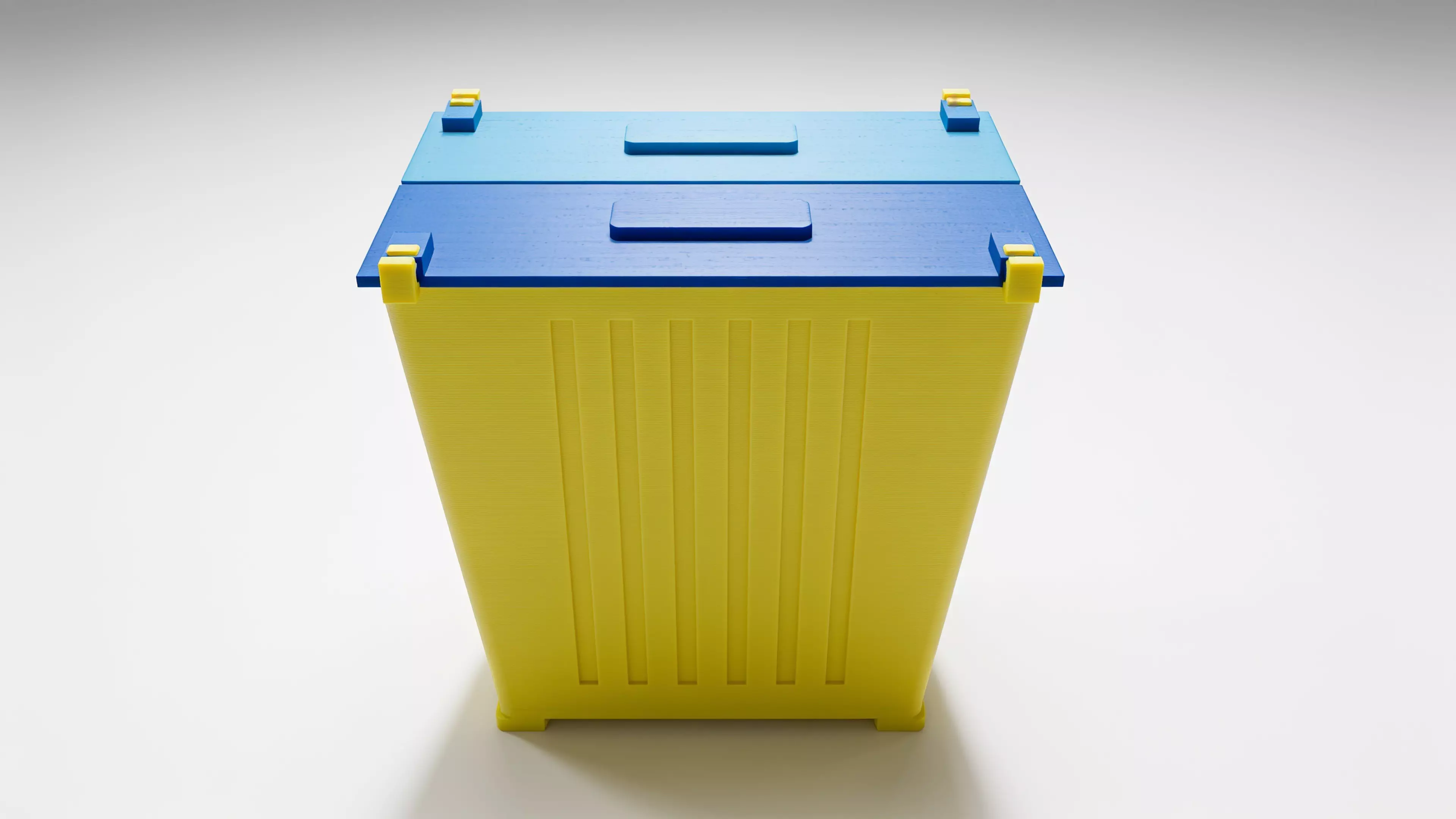 A miniature industrial-dumpster-styled desk trash catcher: a tapered corrugated bin body with two hinged flip lids that meet in the middle, complete with corner skid feet.