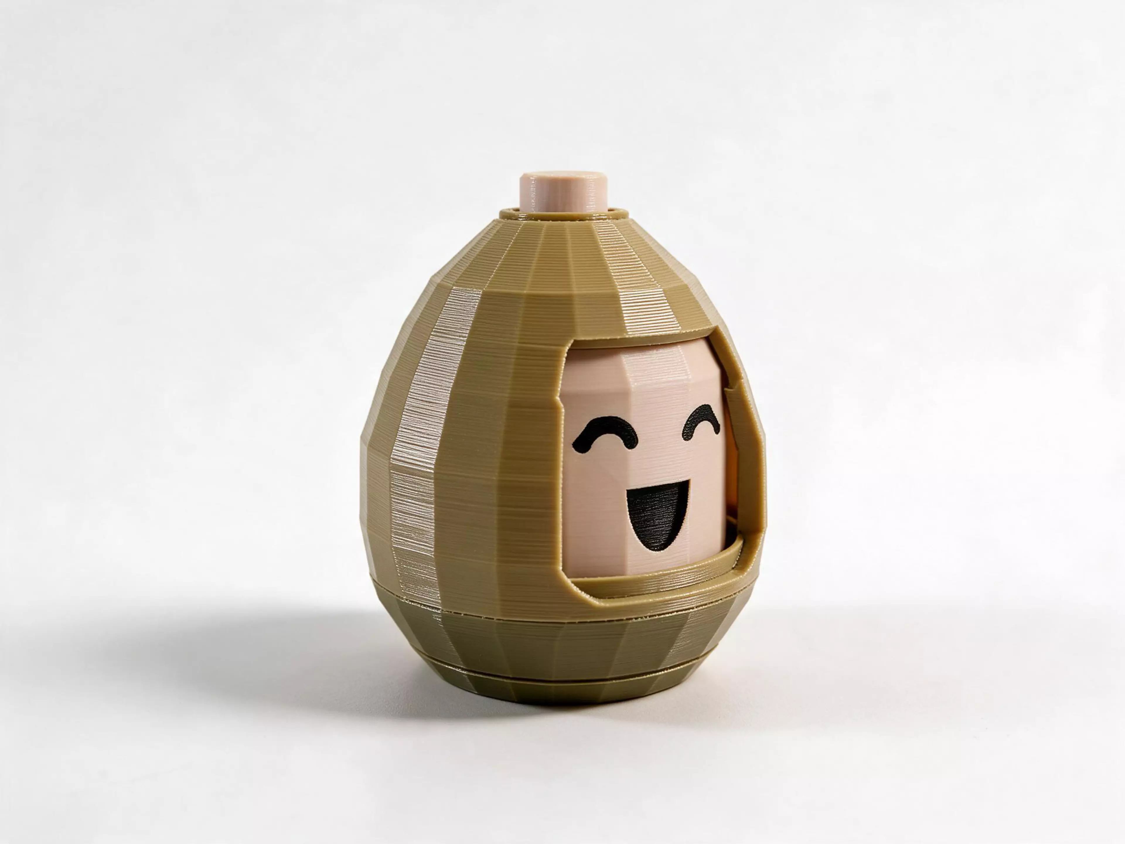 A push-button mood egg for the desk: press the button on its crown and the face in the window turns to the next expression — happy, surprised, sleepy, sad, angry, and round again. Fully mechanical: a retractable-pen style push-to-turn cam (plunger crown, rotor, fixed crown) and one return spring. The shell twists off its base to assemble the egg and to swap the expression core.