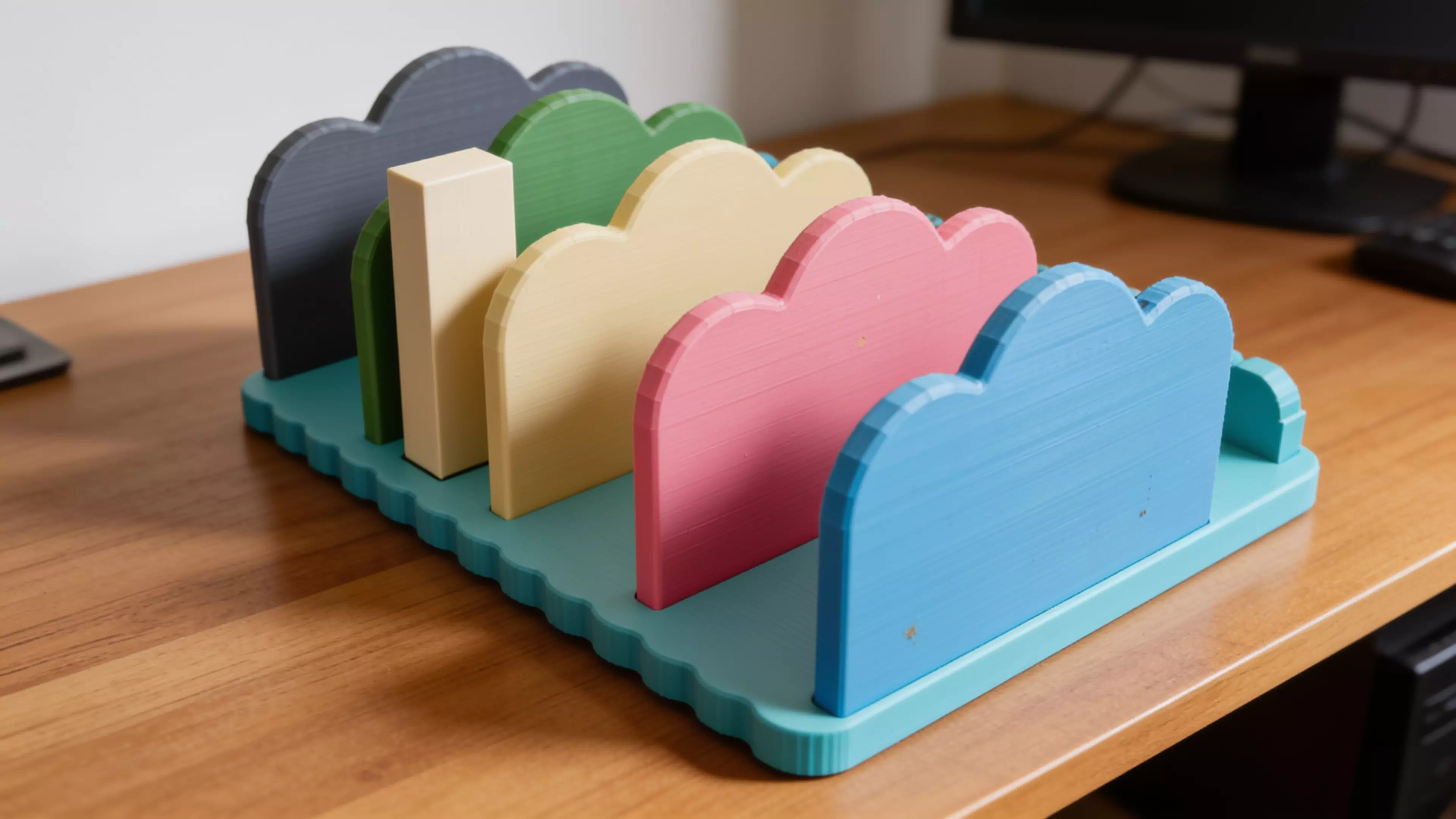 A pastel "cloud" bookshelf rack that holds 4 DGX Spark nodes upright on edge in side-by-side slots, with cloud-silhouette dividers, a scalloped base, and a rear cable-comb rail; 2 unique printed parts (base + 5 identical dividers), assembled overall 246 × 212 × 102 mm.