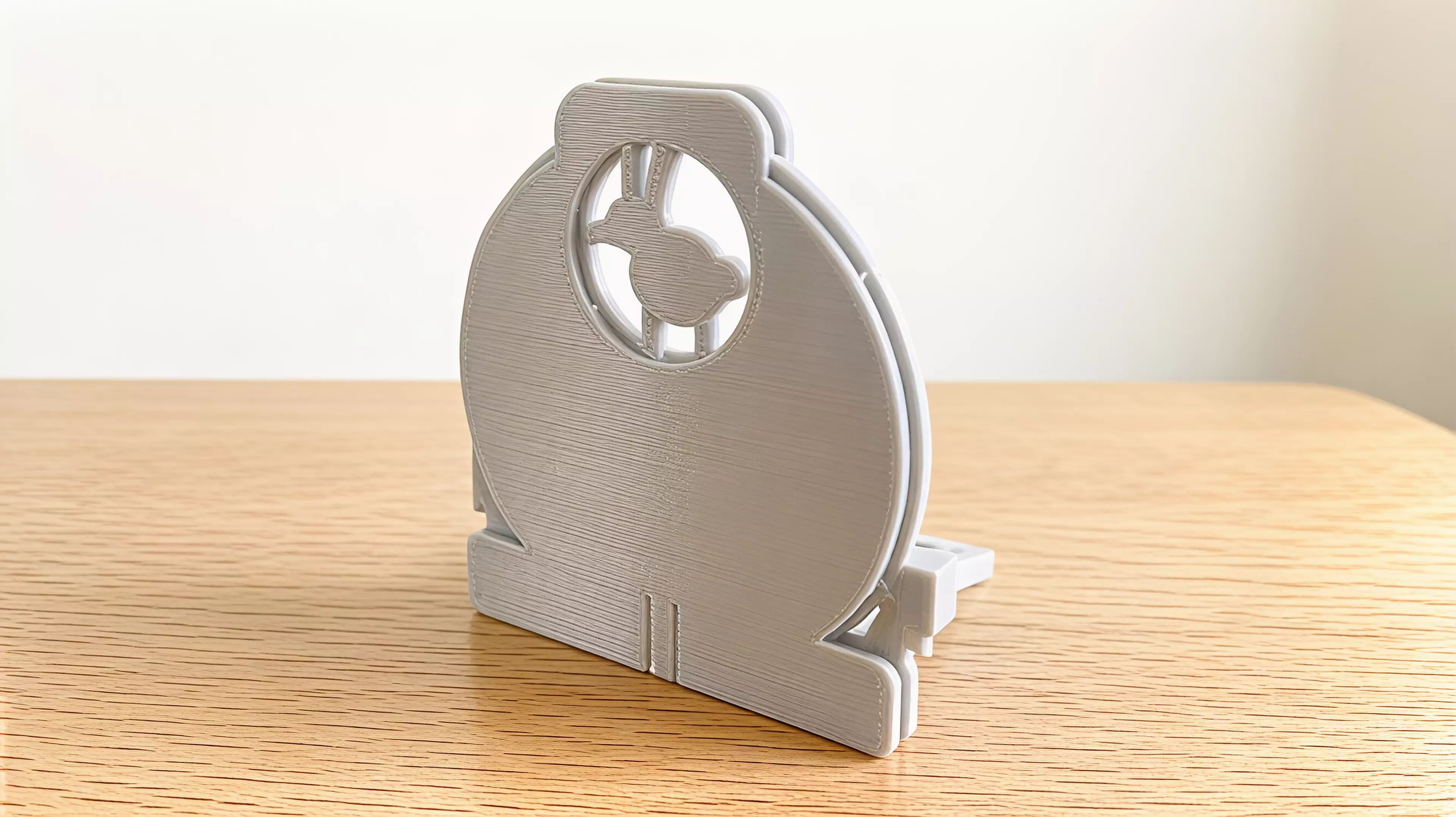 A four-part hand-powered moon gate with a captured reel that casts indexed rabbit, fox, and owl shadows from an ordinary external phone flashlight.