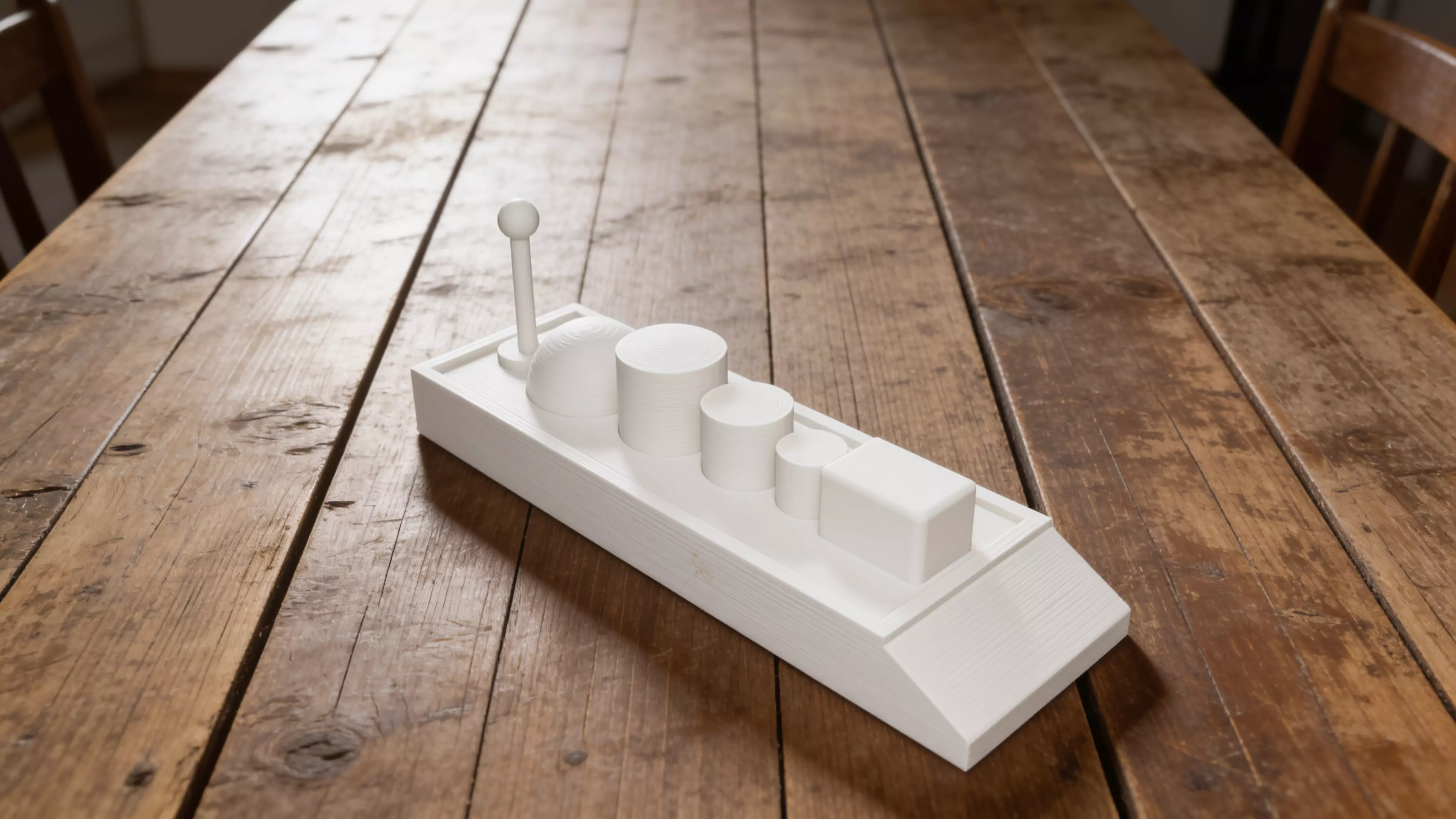 A toy cargo barge — a low, flat-bottomed hull with a raked bow and flat stern — plus six separate deck-cargo pieces (mast/beacon, dome, three drums, and a crate) that peg into sockets on the deck, matching the sketch's assortment.