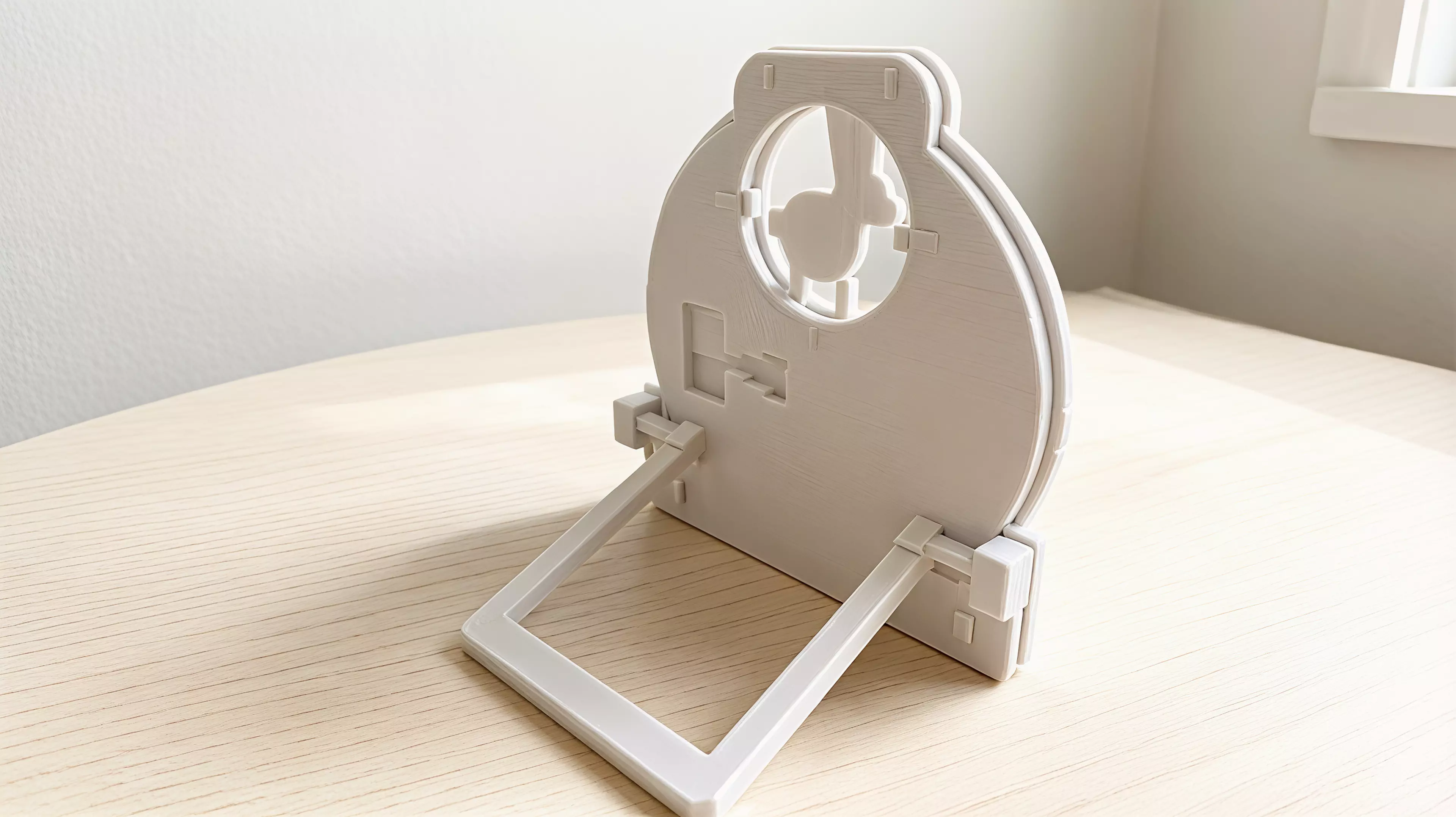 A four-part hand-powered moon gate with a captured reel that casts indexed rabbit, fox, and owl shadows from an ordinary external phone flashlight.
