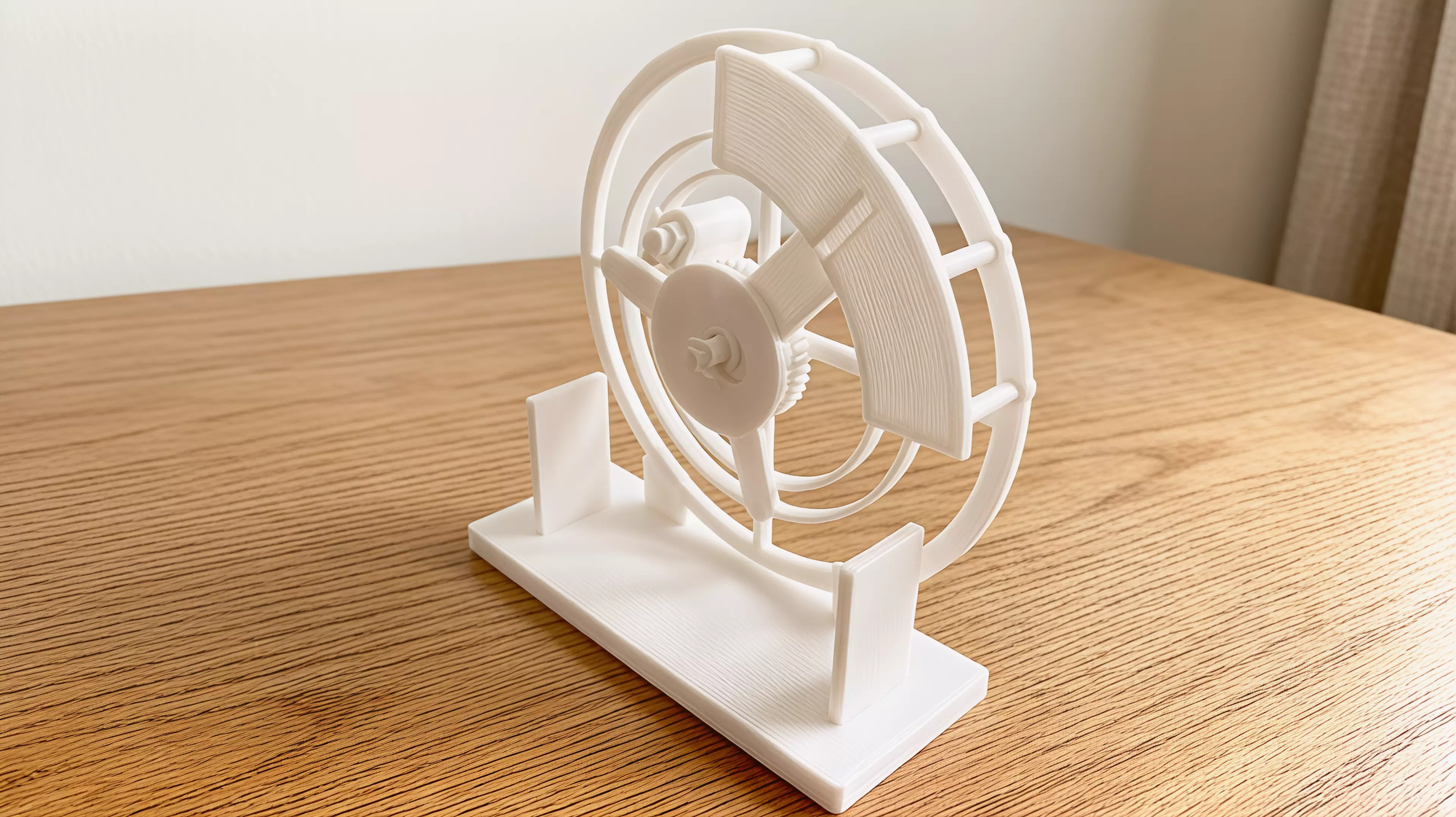 An all-printable hand-cranked desktop automaton in which a geared carrier guides a captive moon through a visible orbit and back through a fixed C-shaped mouth every two crank turns.