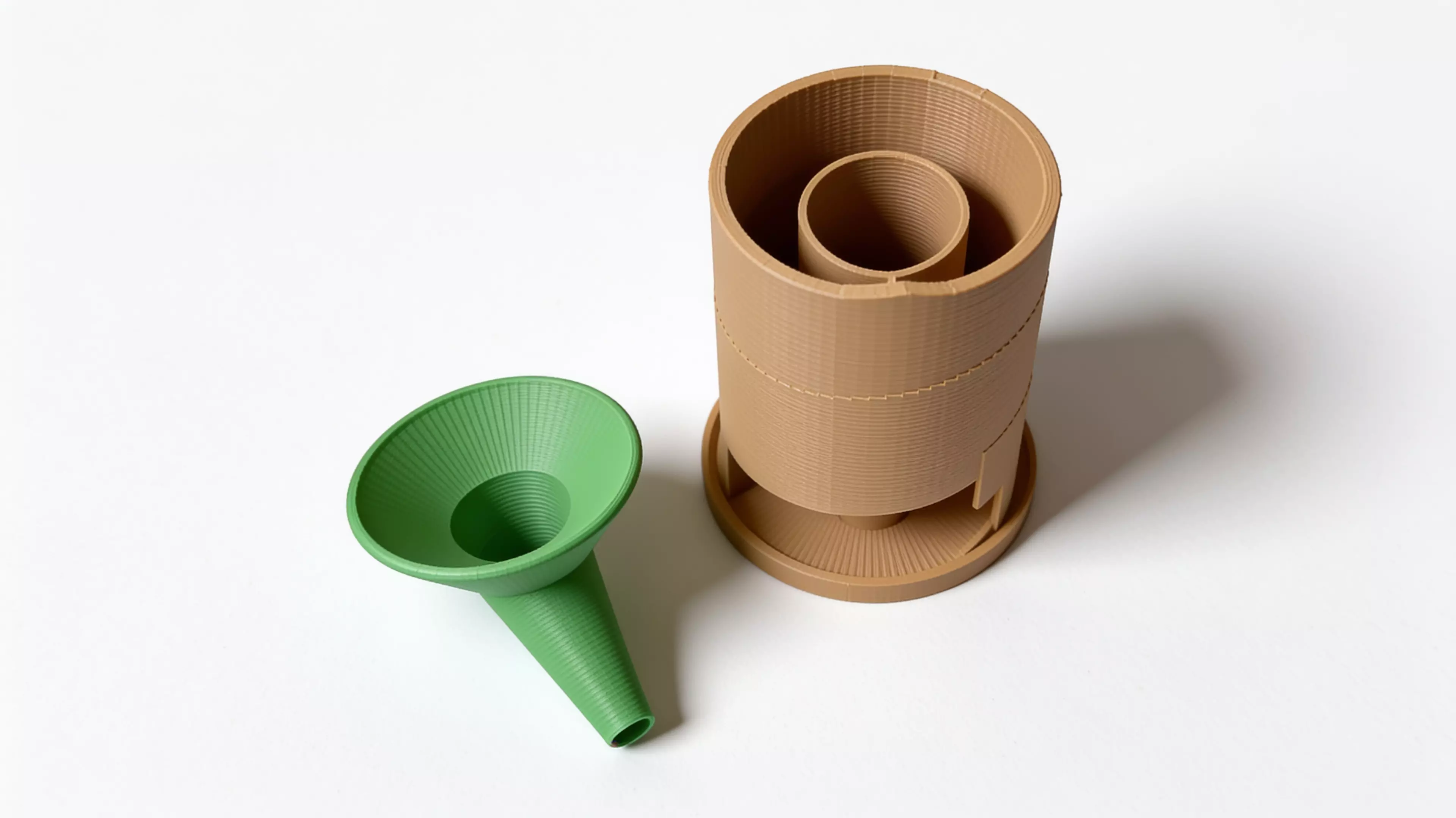 A 210 mm tall helical dice tower: a funnel hopper feeds dice onto a spiral ramp that winds 2.42 turns around a central pillar, contained by overlapping guide walls, exiting through a domed chute near the base onto an integrated landing tab.