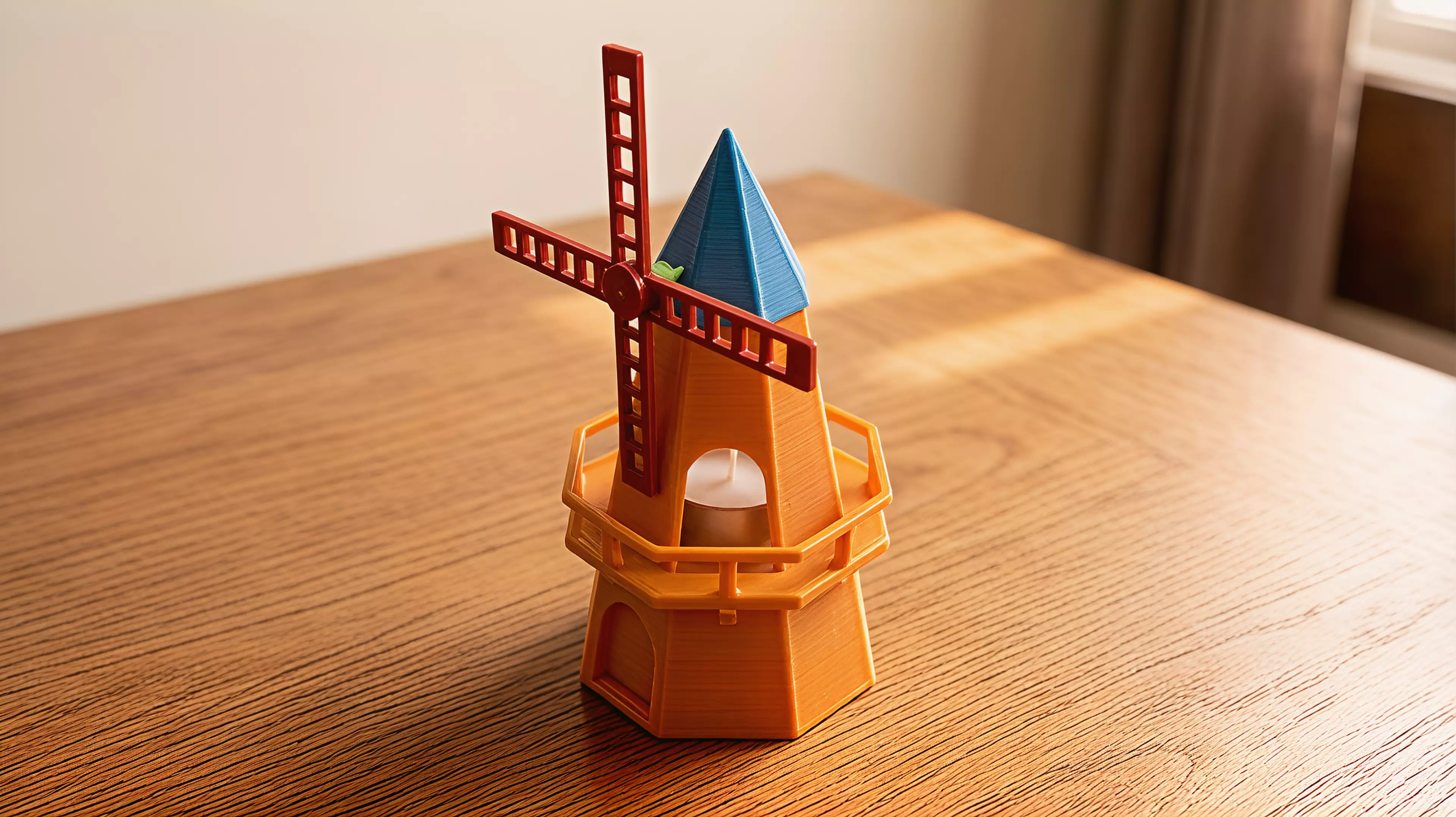 A ~250mm-tall desk windmill tea light holder in a minimal, crisp-edged style: a hollow tapered octagonal tower with an arched candle-access opening, a railed balcony, a conical cap, and a 4-blade lattice sail rotor that spins freely on a brass pin.