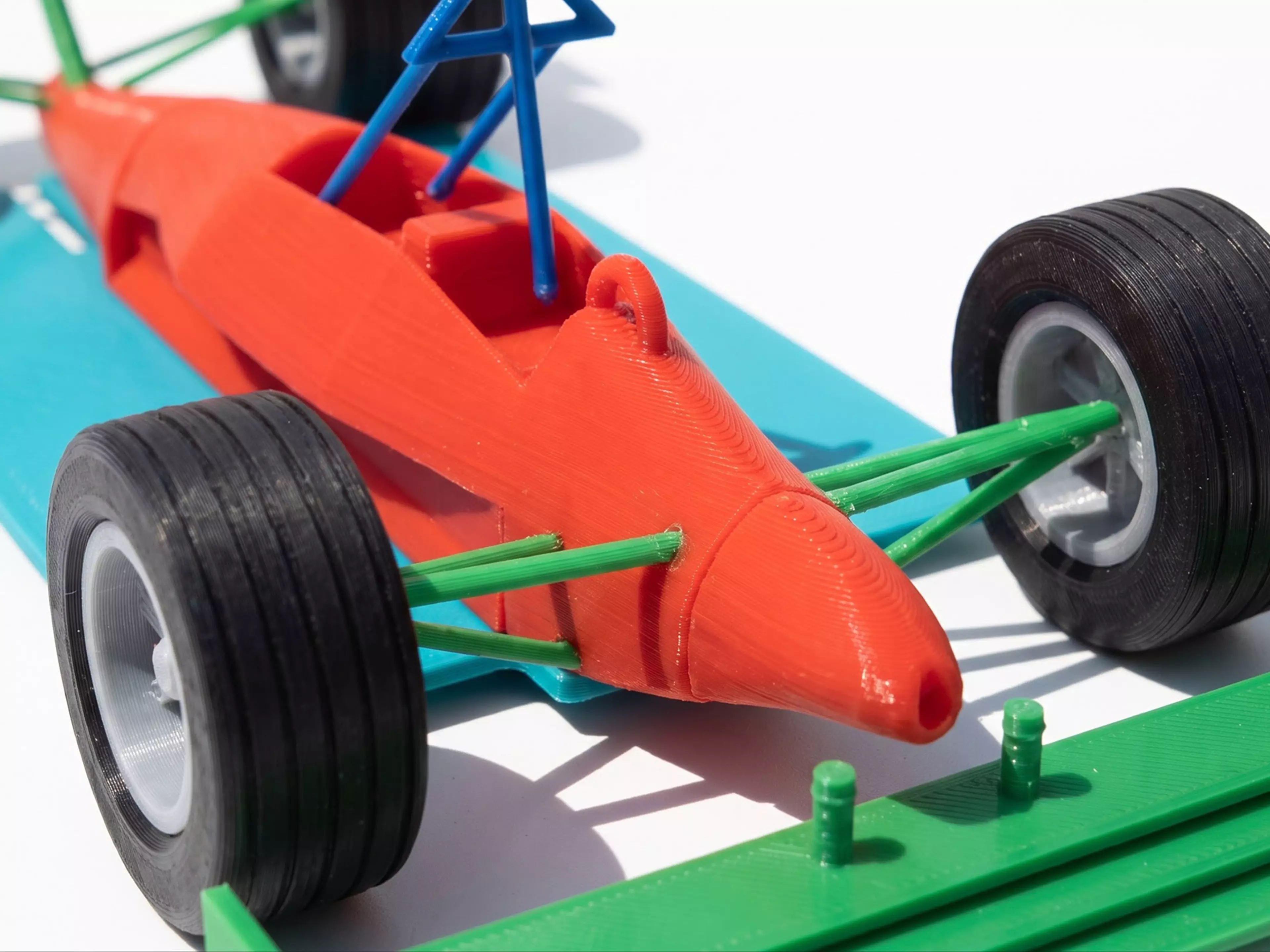 A 10-part, 17-piece 1:16 scale Mercedes-style F1 car: silver body shell (tub/nose/sidepods/engine cover with integrated suspension arms and axle stubs), black floor/diffuser, black front and rear wings, black halo, 4 rotatable wheels (2 rim + 2 tire designs, front/rear) with a center-lock retaining…
