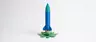 A one-of-a-kind 180 mm-tall display piece: a classic retro finned rocket that plugs into an open-bloom lotus-flower pedestal base — two separate, removable parts, each a different color.