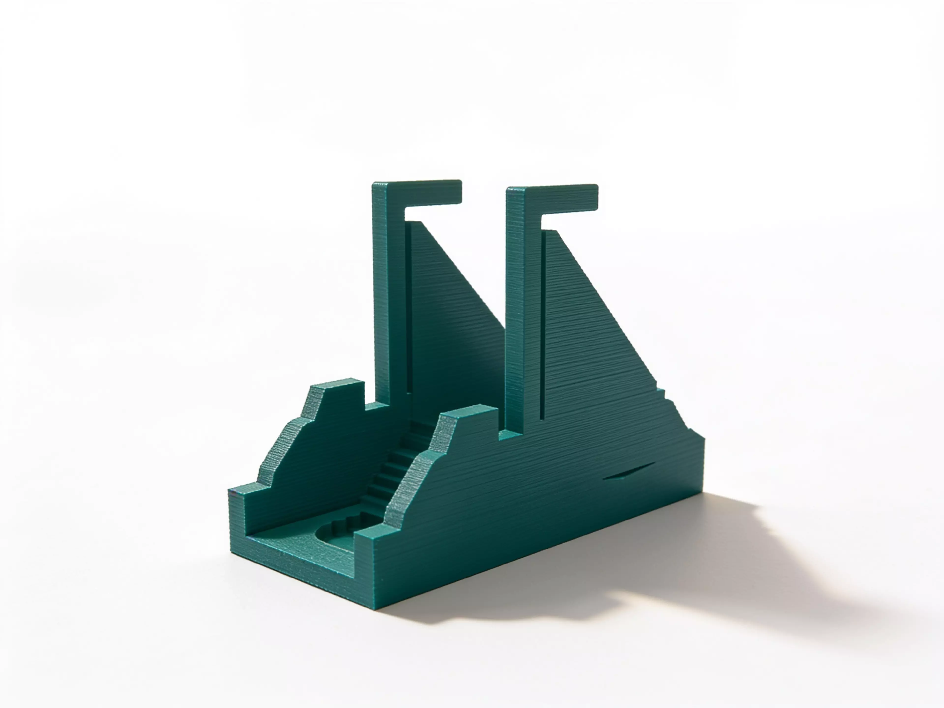 A one-piece desk sculpture whose sailing-ship silhouette becomes a breaching-whale and crescent-moon aperture after one exact quarter-turn.
