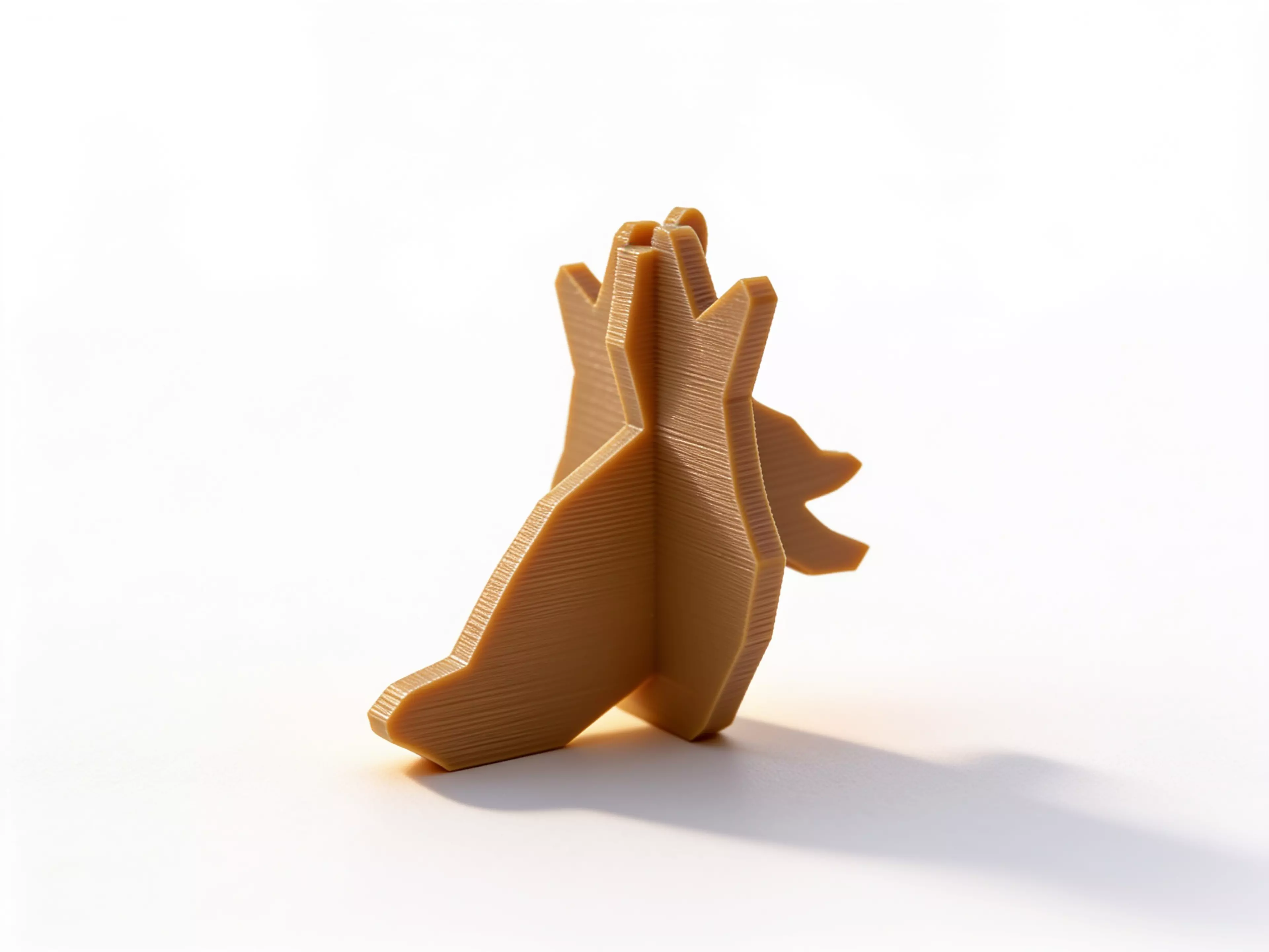 A palm-sized one-piece shadow toy whose broad faces project a horned owl and, after a 90-degree turn, a leaping rabbit under an ordinary external phone flashlight.