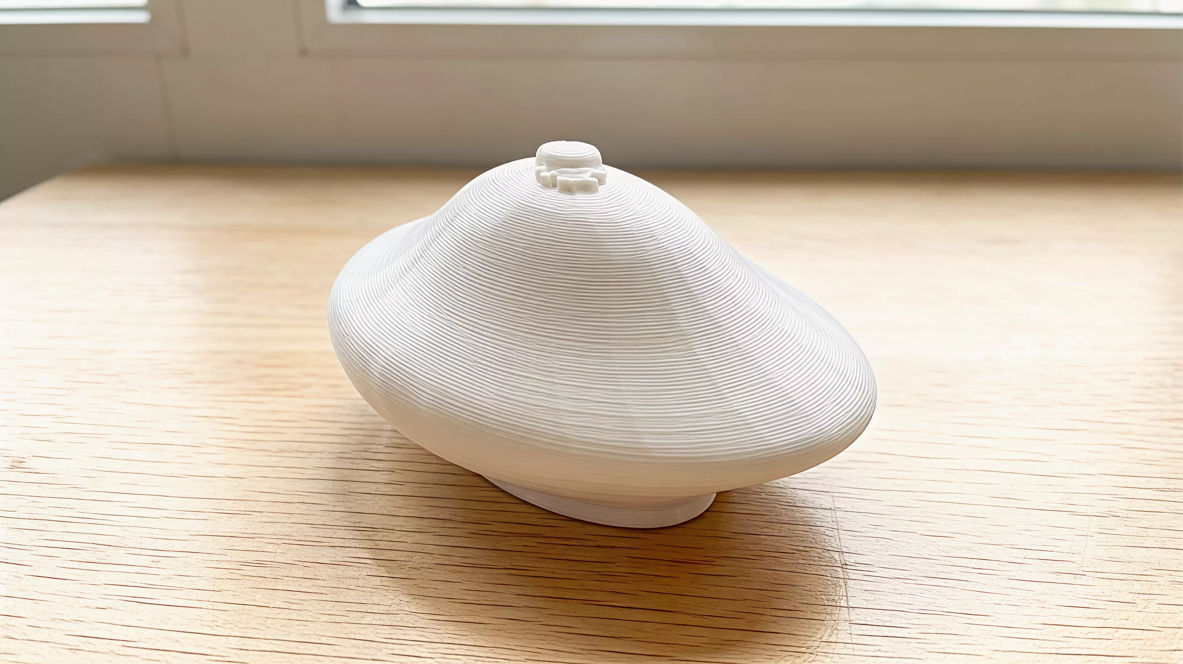 A palm-size one-piece desk wobbler designed for a sideways flick or gentle roll, with a raised smiling-star home cue.