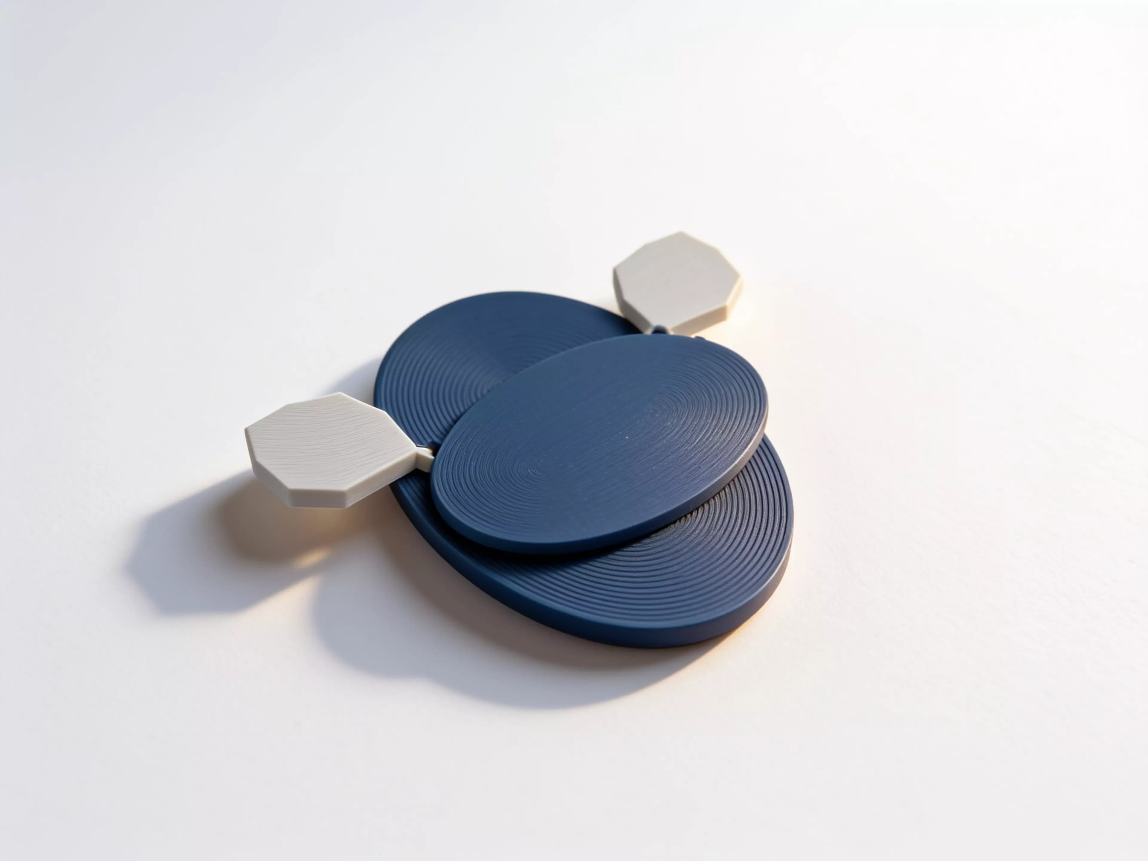 A three-part, hardware-free hand-powered desk toy: sweeping the left wing rotates the meshed pair from a low crescent form toward a moth silhouette with six star apertures.