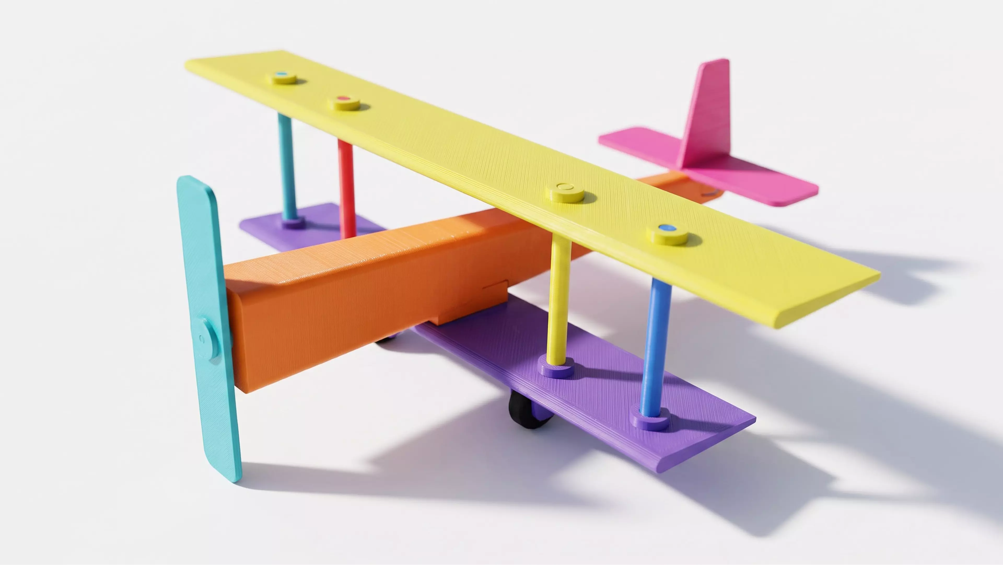 A pocket-size rubber-band-powered vintage biplane: a two-wing hand-launch glider with a free-spinning propeller driven by a twisted rubber-band motor housed in the fuselage, all in a single print color.