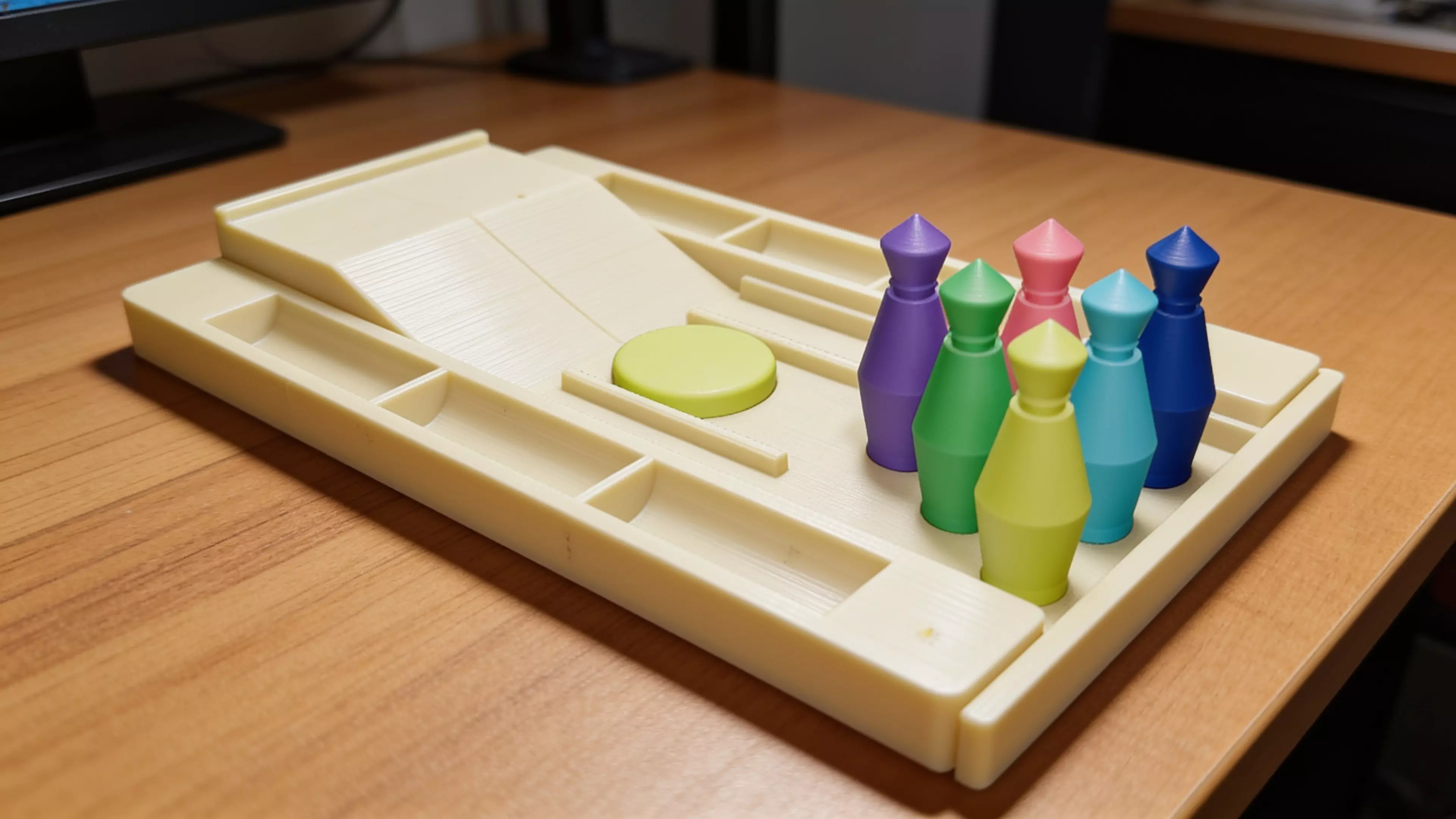 A pocket bowling toy: a lane tray that ramps into a flick-launch pad and doubles as nested storage, six molded pins in a 3-2-1 triangle, and one flick disc — flick the disc off the ramp to send it down the lane into the pins.