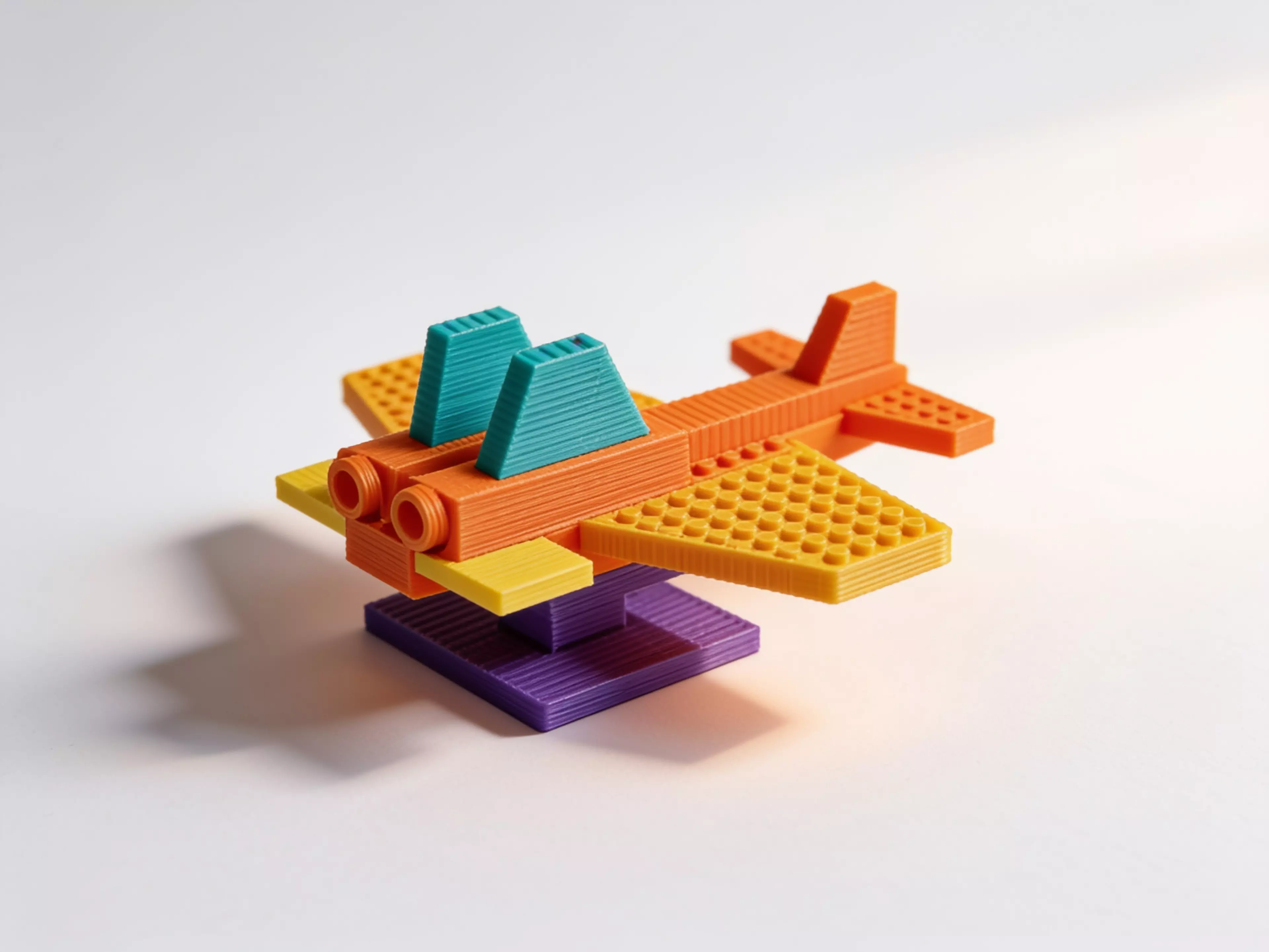 A single-piece, stylized F-14 Tomcat brick-jet (set-c aggressive wedges) with a LEGO-standard stud grid on its upper surfaces so real System bricks/plates clutch on; flat belly for desk display. Printed belly-down, PLA, supports on.