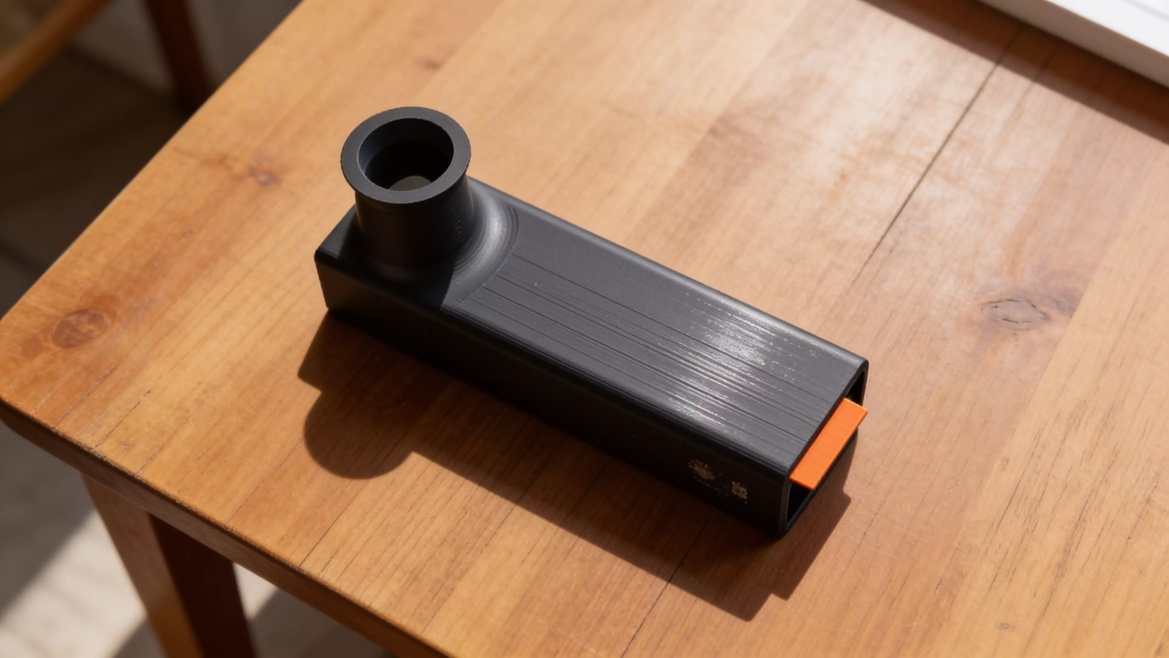 A pocket observatory for eclipse day: point it sunward, shrink the orange tab’s shadow to a dot, and a crisp solar crescent appears on the internal screen — you never look at the sun. Optics-calibrated 0.7 mm pinhole, 55° glare-hooded eyepiece, prints in one piece with zero supports in ~8.5 h. 152 × 38 × 74 mm, PLA.