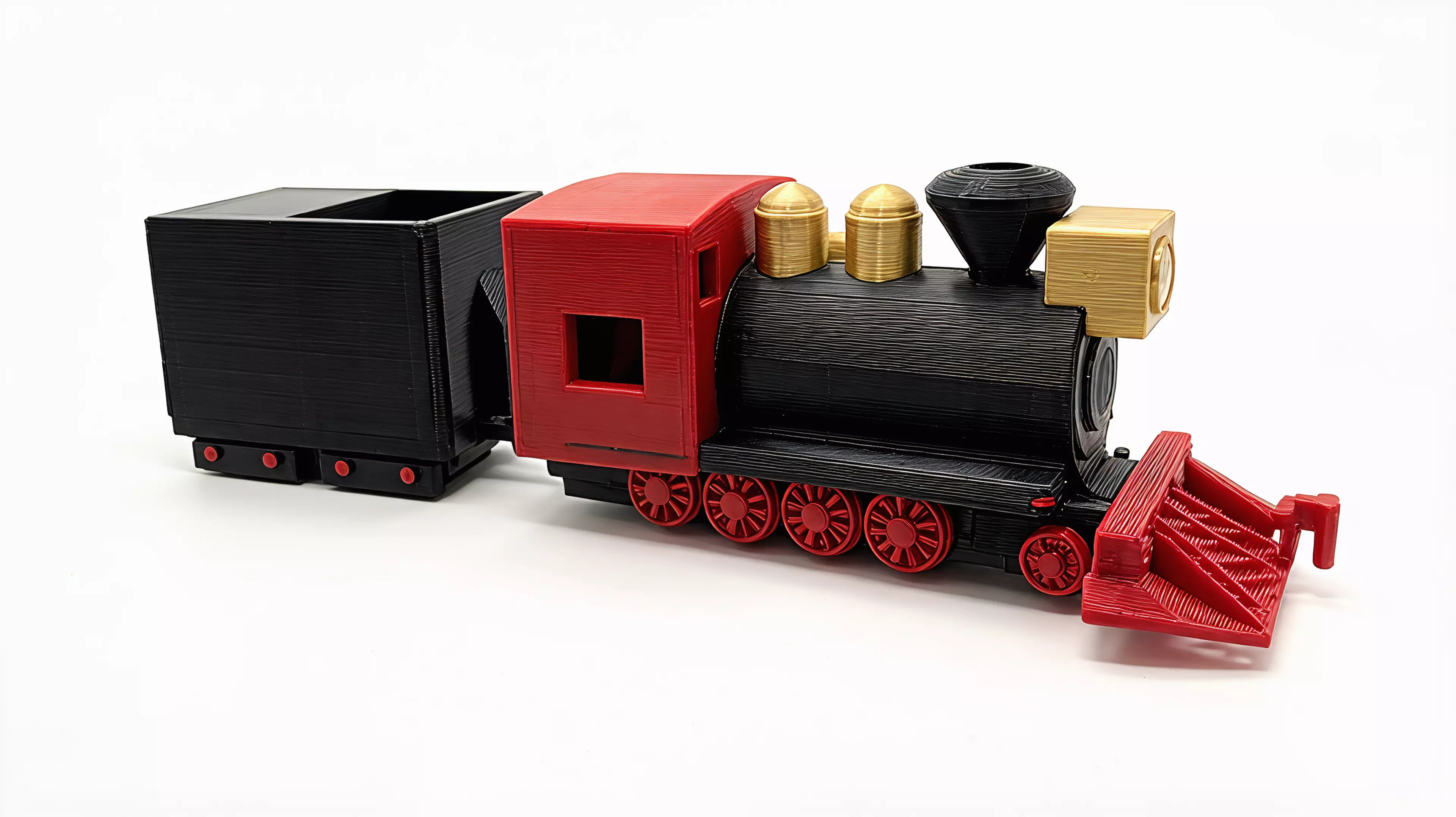 A 1:87 buildable desk model of Silverton Railroad No. 100, with a four-driver 2-8-0 profile, separate rolling wheelsets, a two-truck tender, and a hook-and-bar coupling.