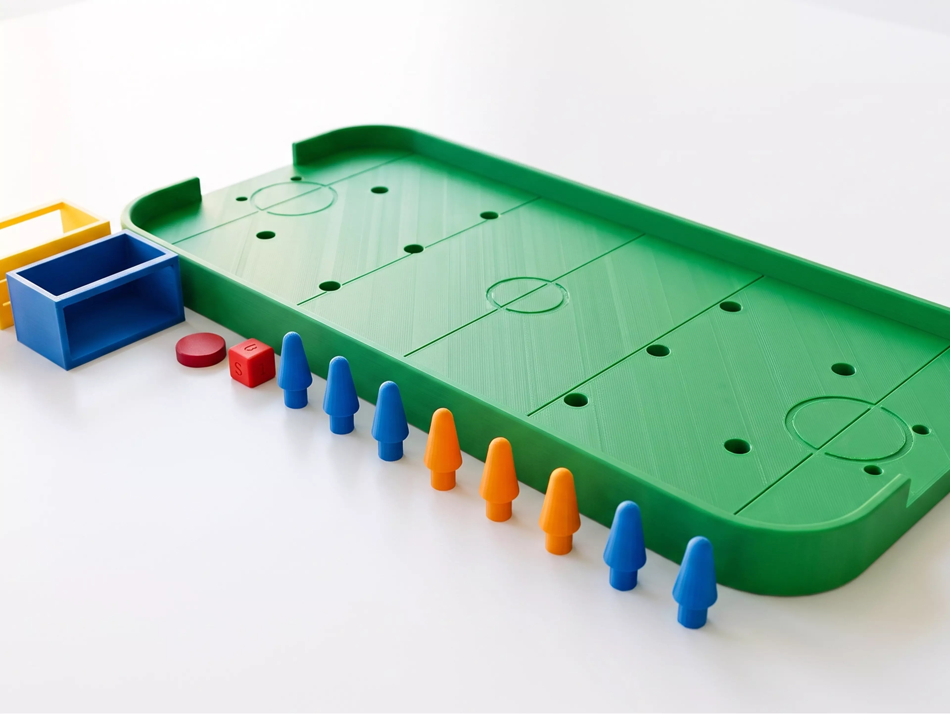 A tabletop hockey game kit: 
1. Role the dice to get how many pin can stand on the field
2. Set the pins' position as your will
3. Choose the angle, flick the puck to score