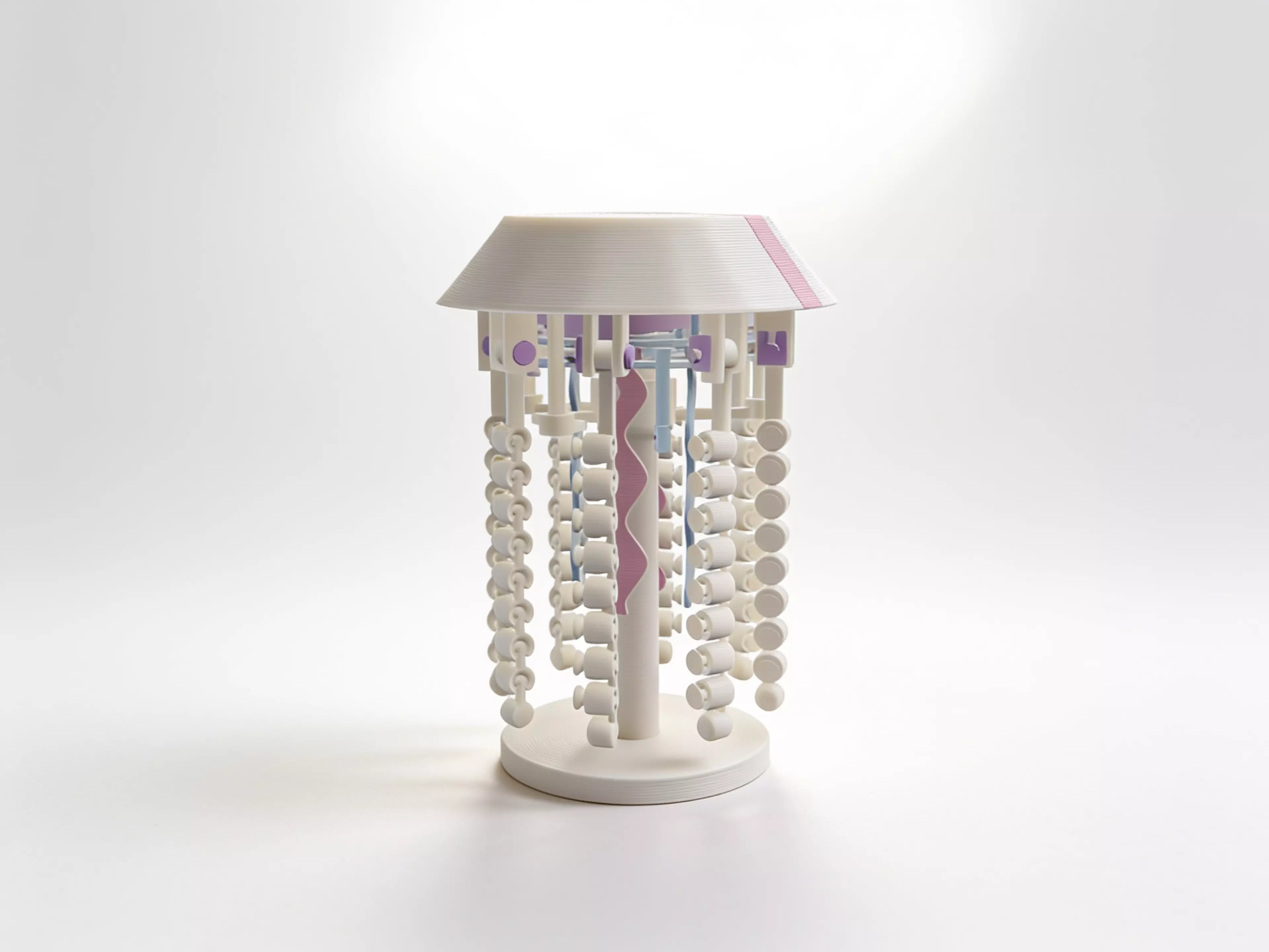 A palm-sized pearl jellyfish with soft pink and blue accents, eight beaded tentacles and four flowing ribbons. Its wind-up mechanism and pressable bell are designed to create a gentle swimming pulse.