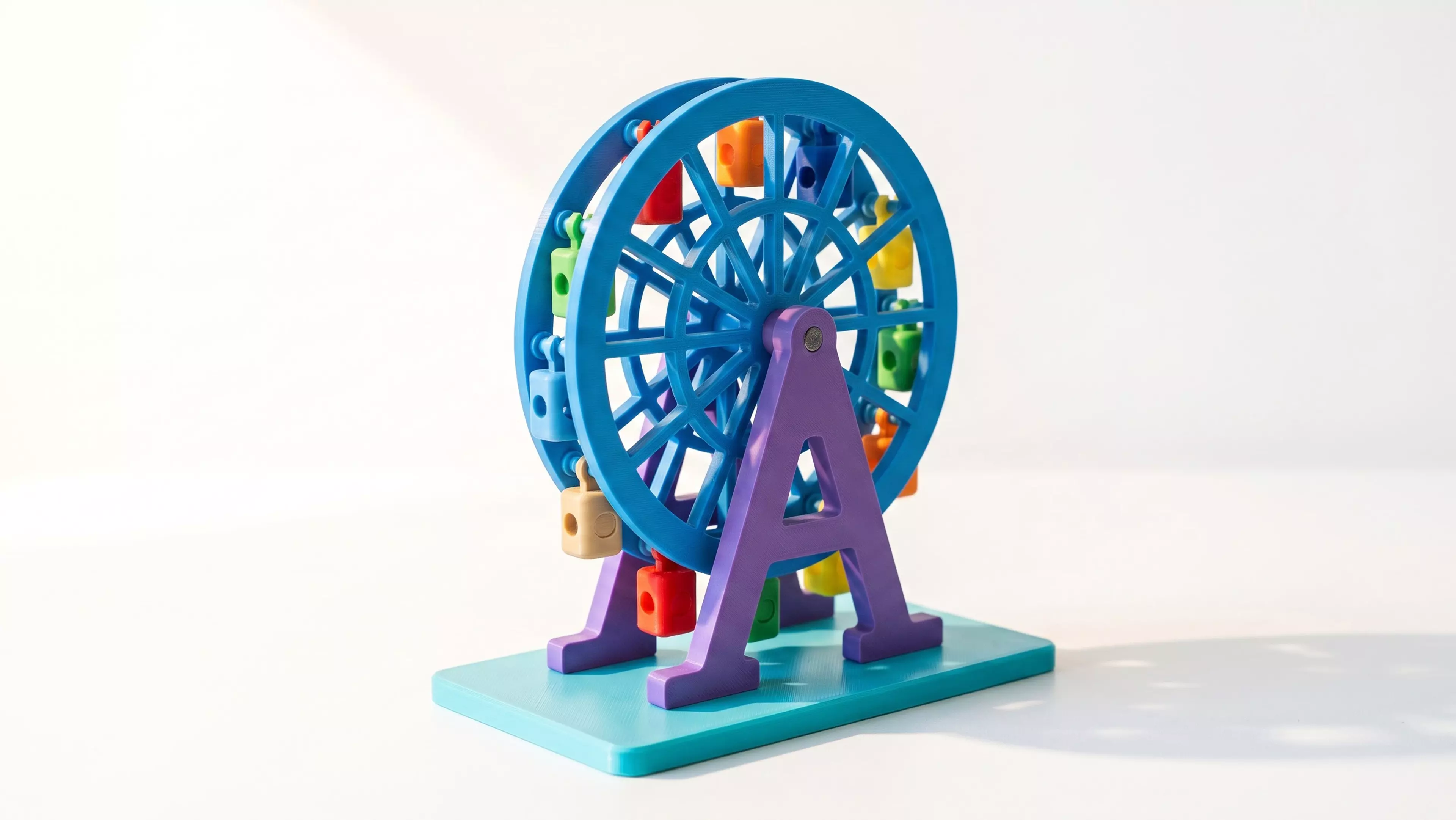 A 185 mm tall, free-spinning Ferris wheel with 12 swinging gondolas that hang upright as the wheel turns, matching the photo's A-frame support and lattice-spoke wheel, split into separately-printable parts for multi-color filament (base/towers in white, wheel rims in a sunset accent color, gondolas…