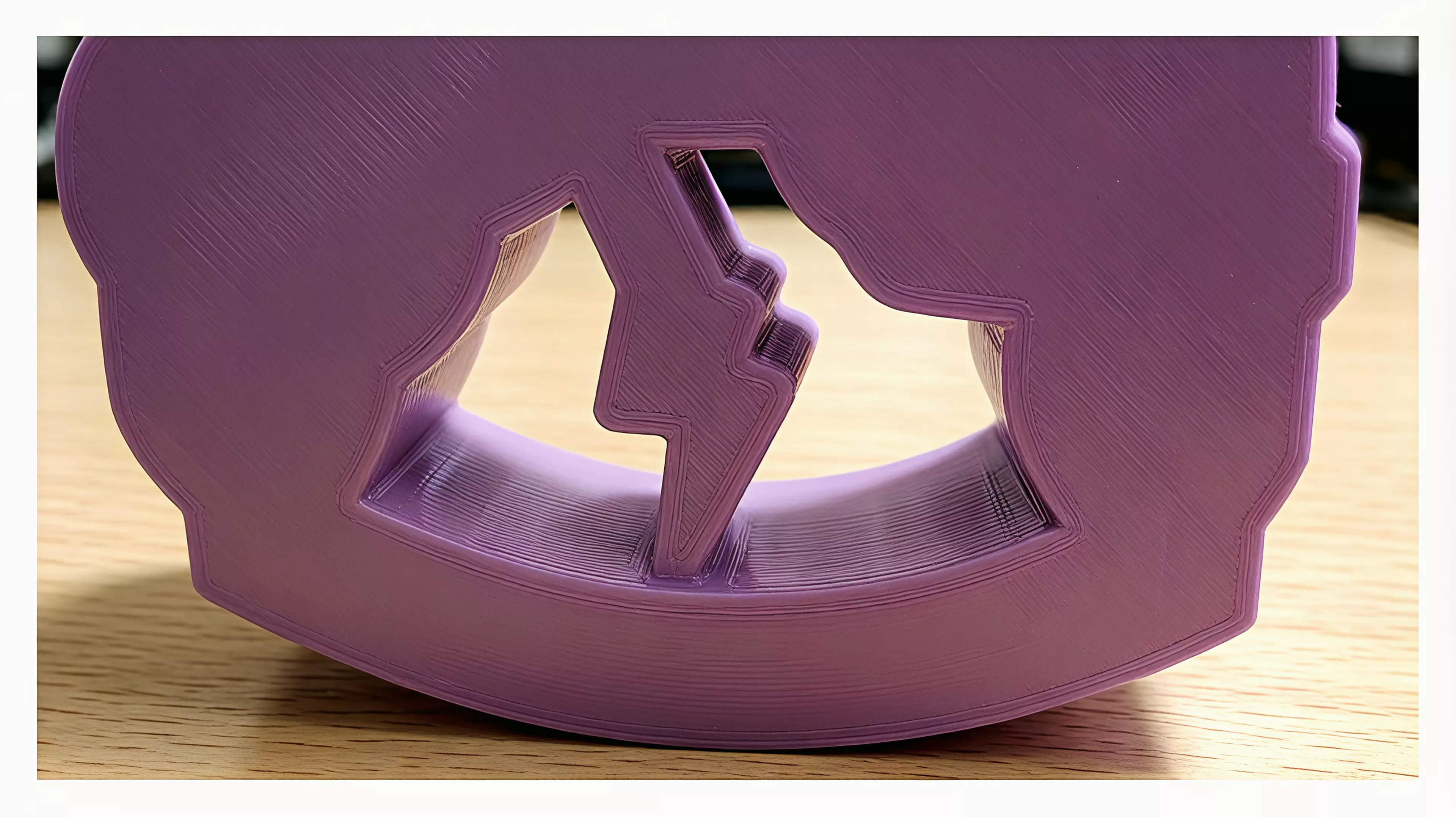 A palm-sized, one-piece storm-cloud desk rocker whose connected lightning bolt sweeps through the open arch as the whole body rocks and returns toward center.