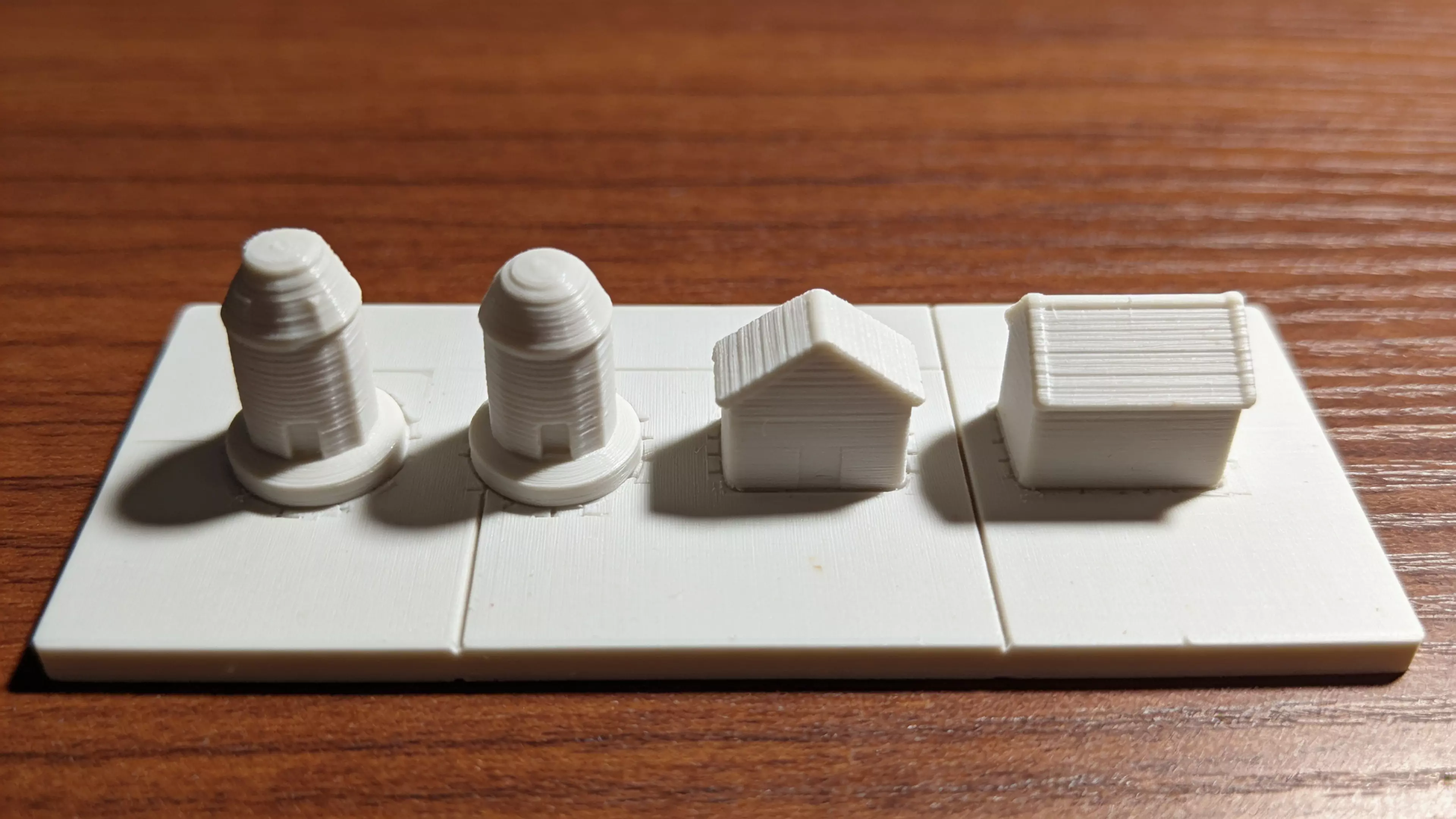 A complete printable set for the game: a 270 × 270 mm snap-together tile board with all 24 spaces engraved, 6 animal tokens (lion, elephant, fox, turtle, panda, eagle), shelter + wildlife-center building pieces, two dice, and a card/money storage tray.