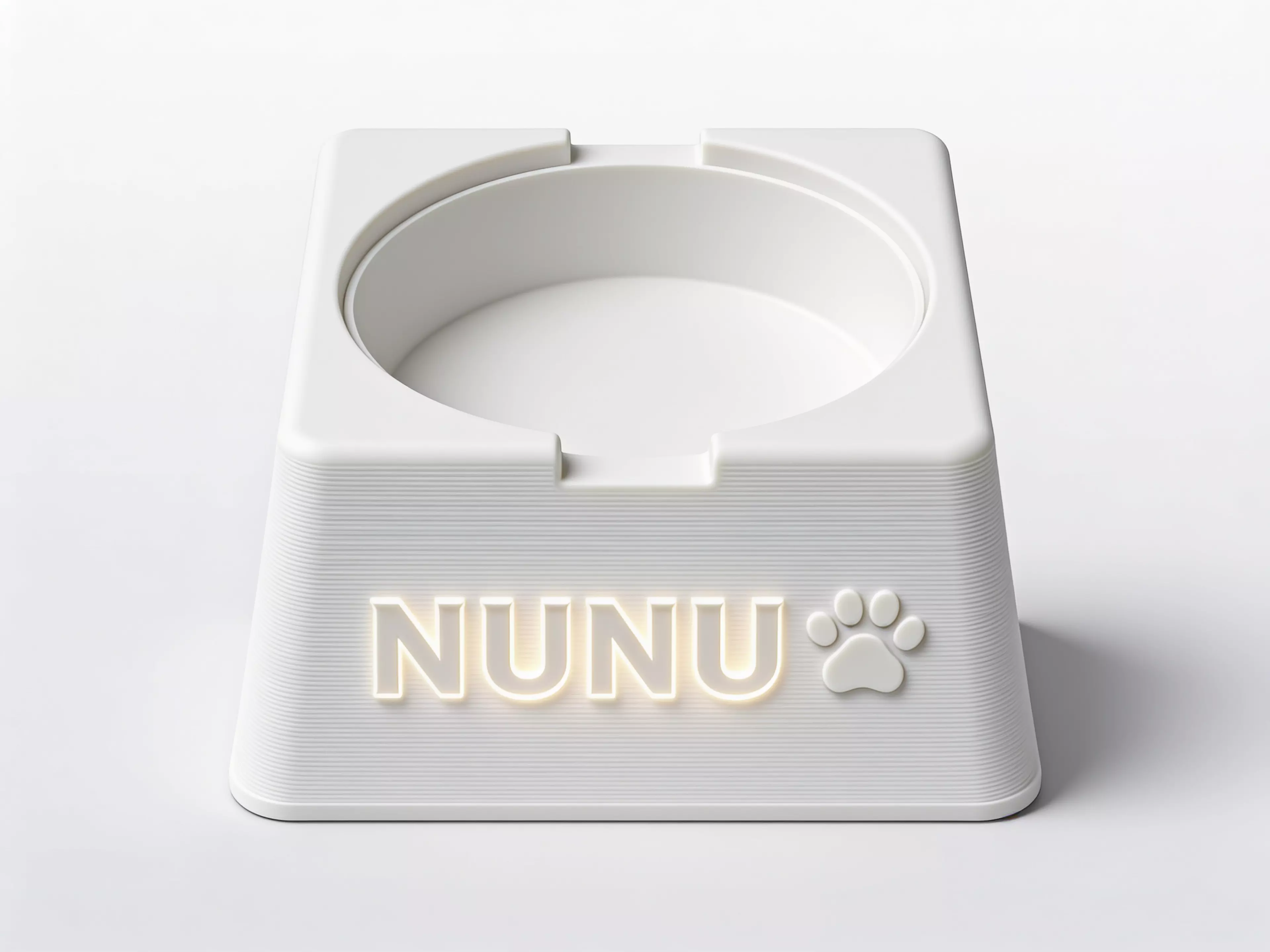 A single-piece, Scandinavian-minimal squircle stand (200 × 200 × 76 mm) that a standard 1-quart stainless bowl drops into from the top and hangs by its rolled rim on an internal support lip, with an anti-spill raised rim, two finger scallops for bowl removal, "NUNU" + paw icon raised on the front…