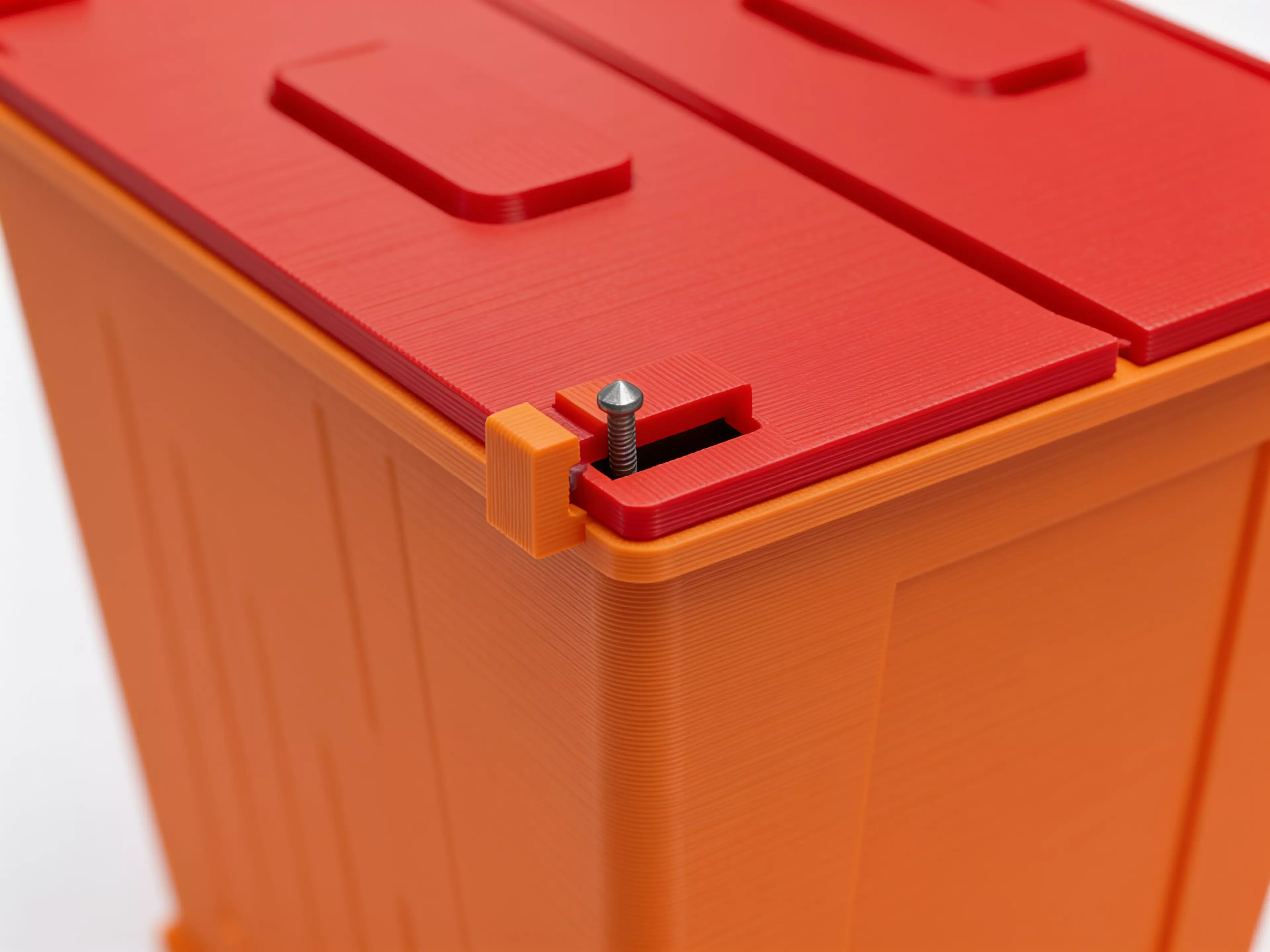 A miniature industrial-dumpster-styled desk trash catcher: a tapered corrugated bin body with two hinged flip lids that meet in the middle, complete with corner skid feet.