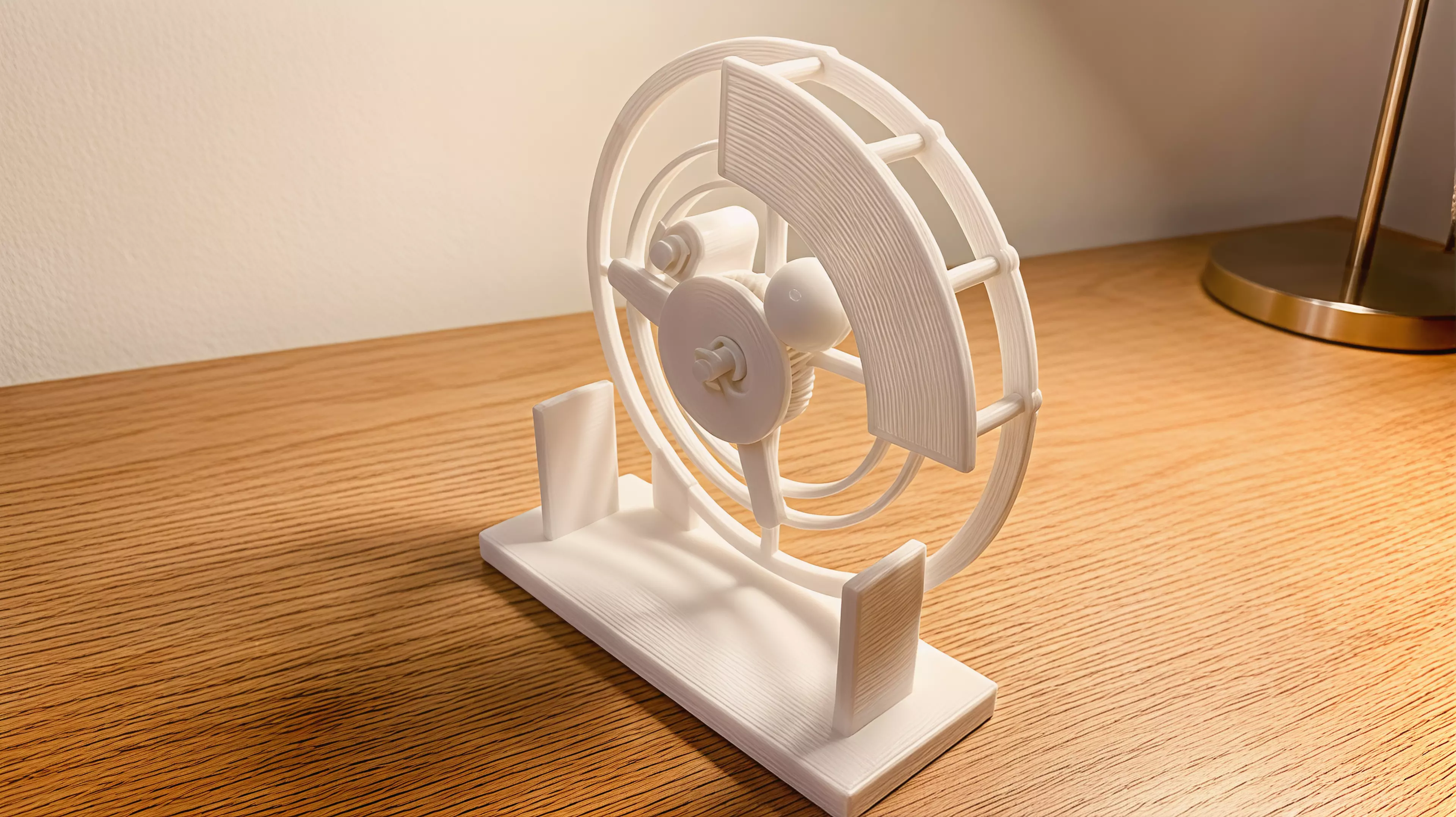 An all-printable hand-cranked desktop automaton in which a geared carrier guides a captive moon through a visible orbit and back through a fixed C-shaped mouth every two crank turns.